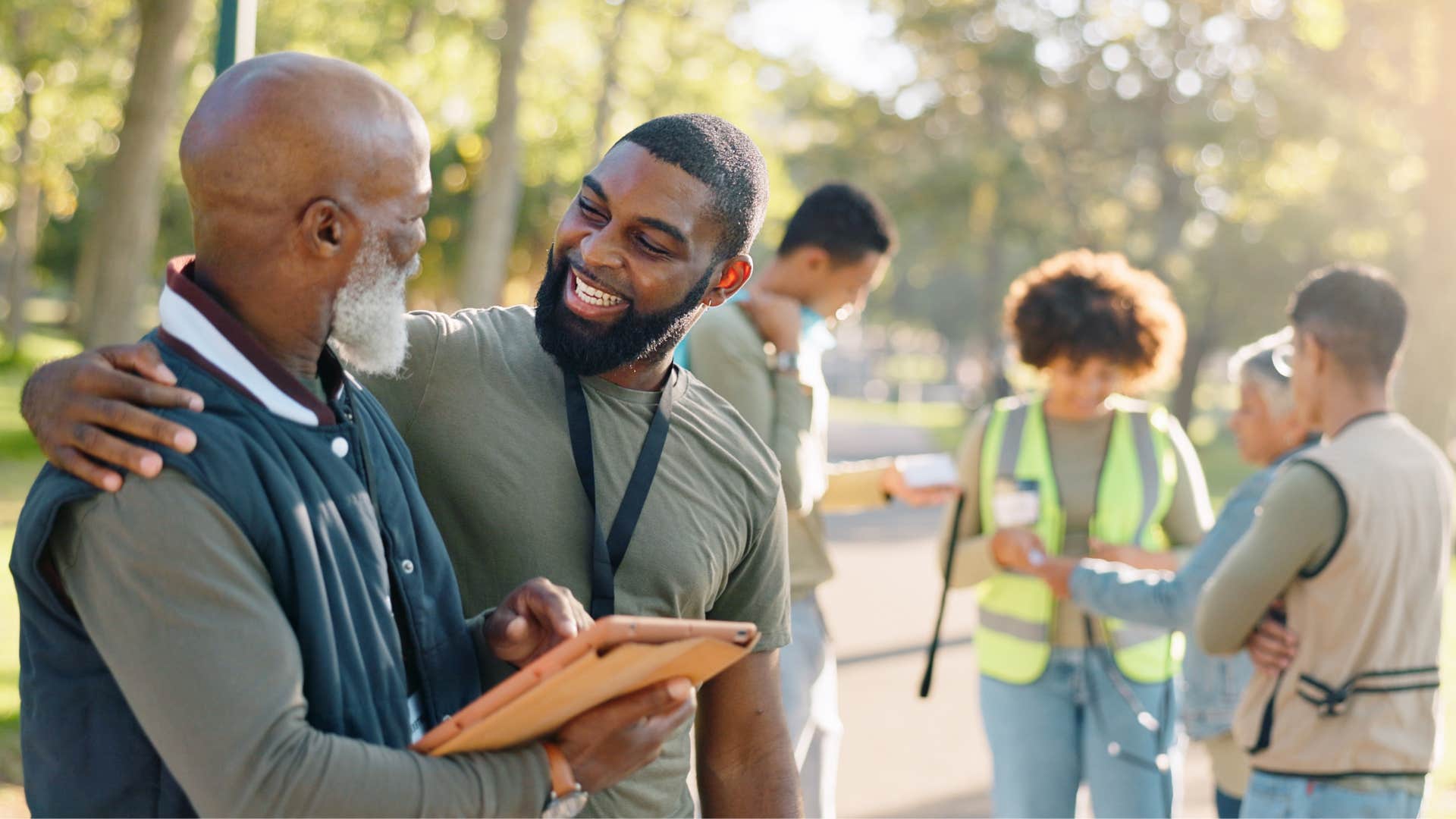 an older man asks his younger friend how to use the tablet