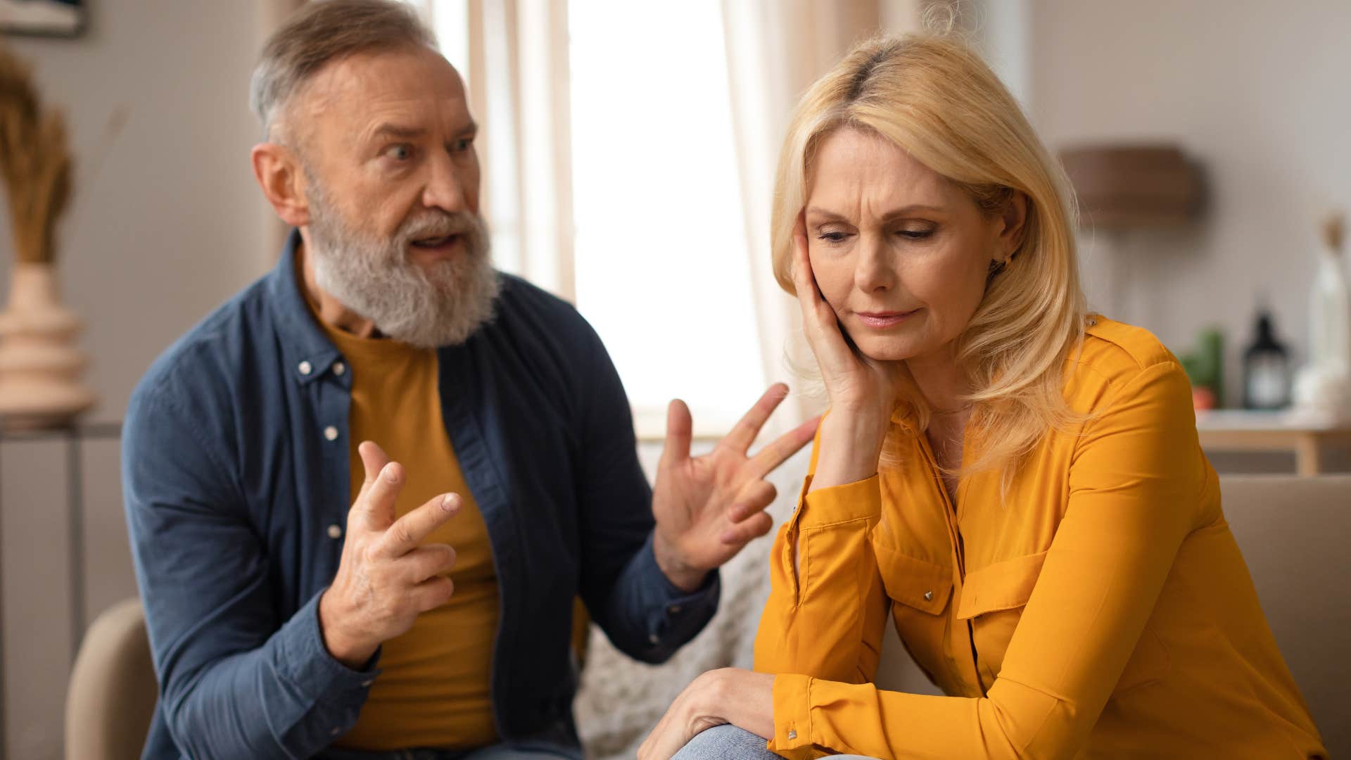 Upset man saying "you're overreacting" to his wife.