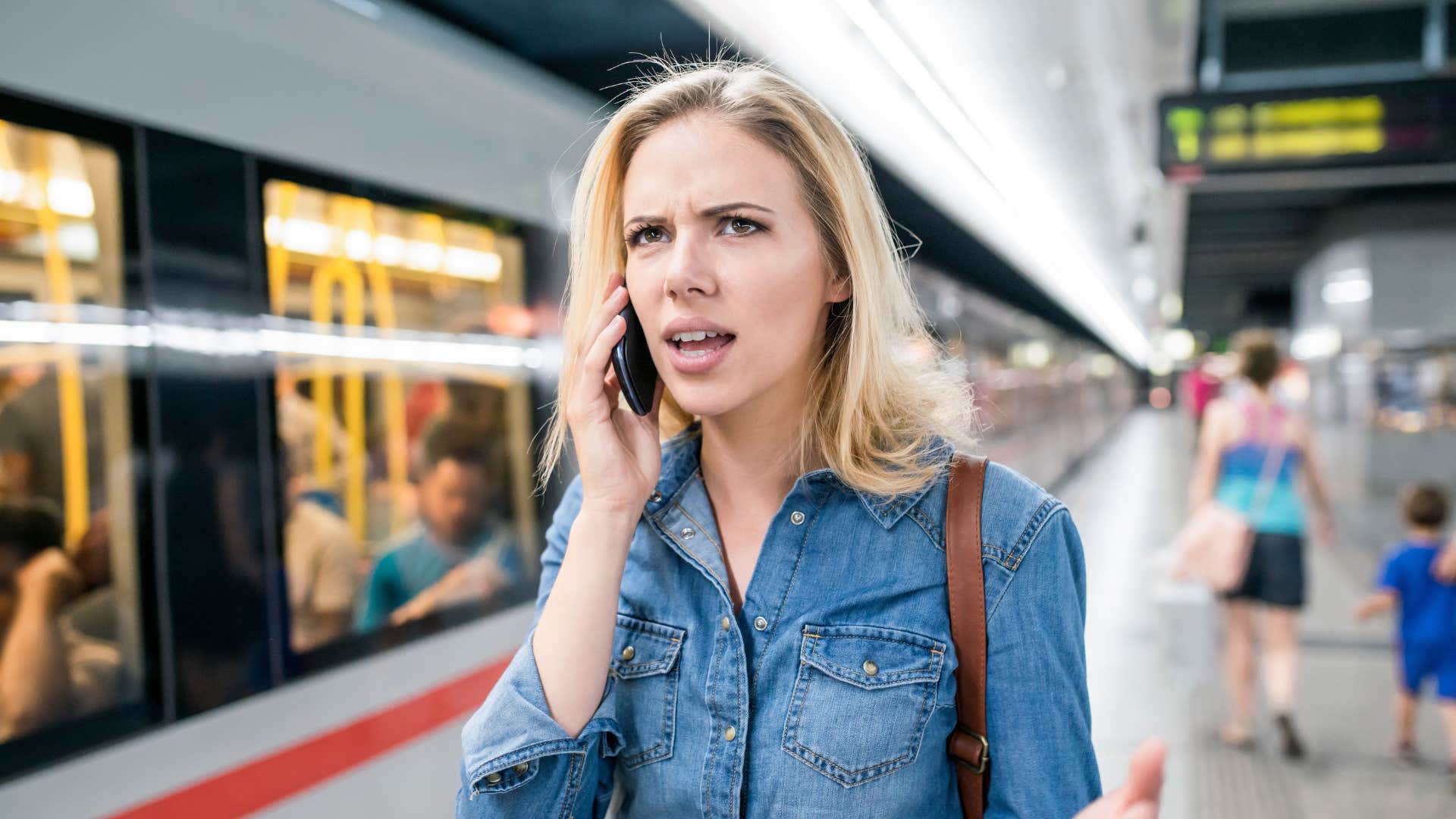 annoyed impatient woman on the phone waiting for train