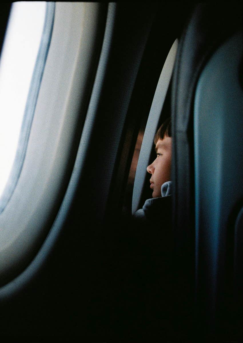 little boy looking out the window on a plane