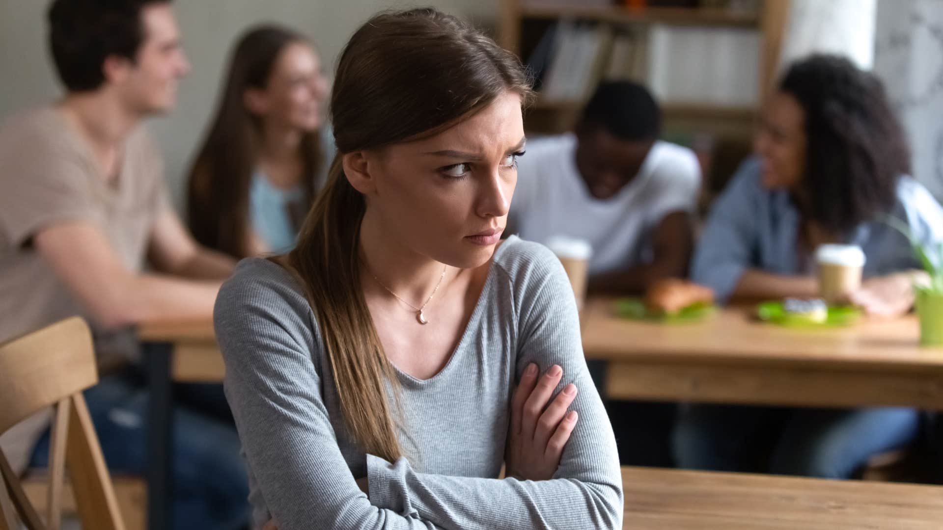 woman in gray refusing to celebrate big wins in life as she sits alone