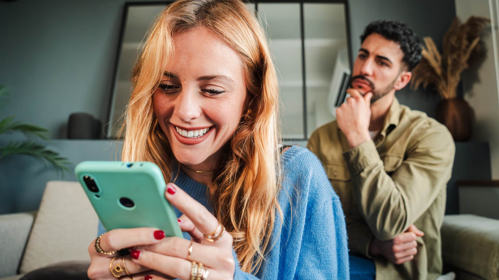man sitting behind his wife who's consistently distracted by a phone