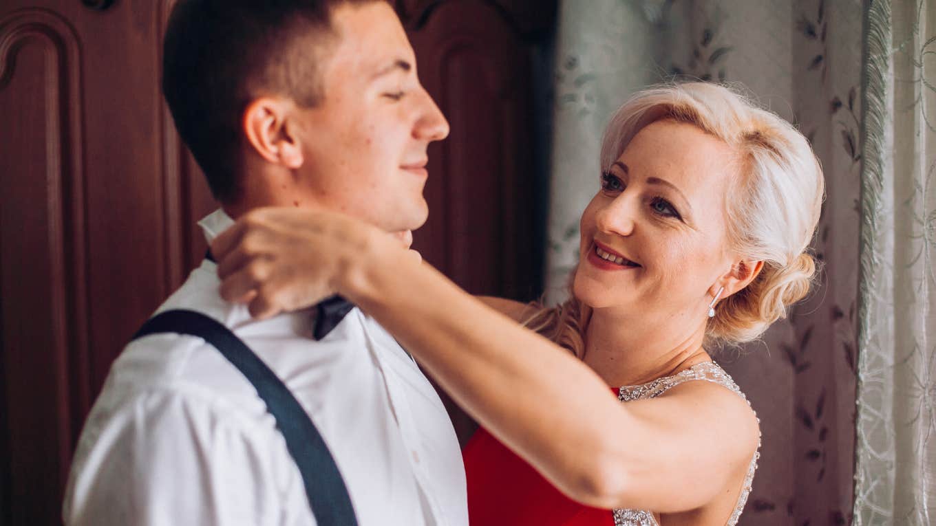 groom's mother helping him get dressed