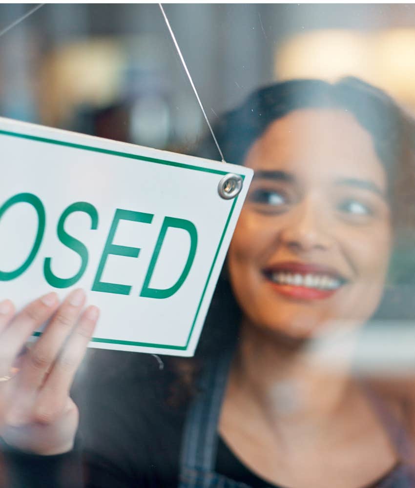 Person turns sign to closed