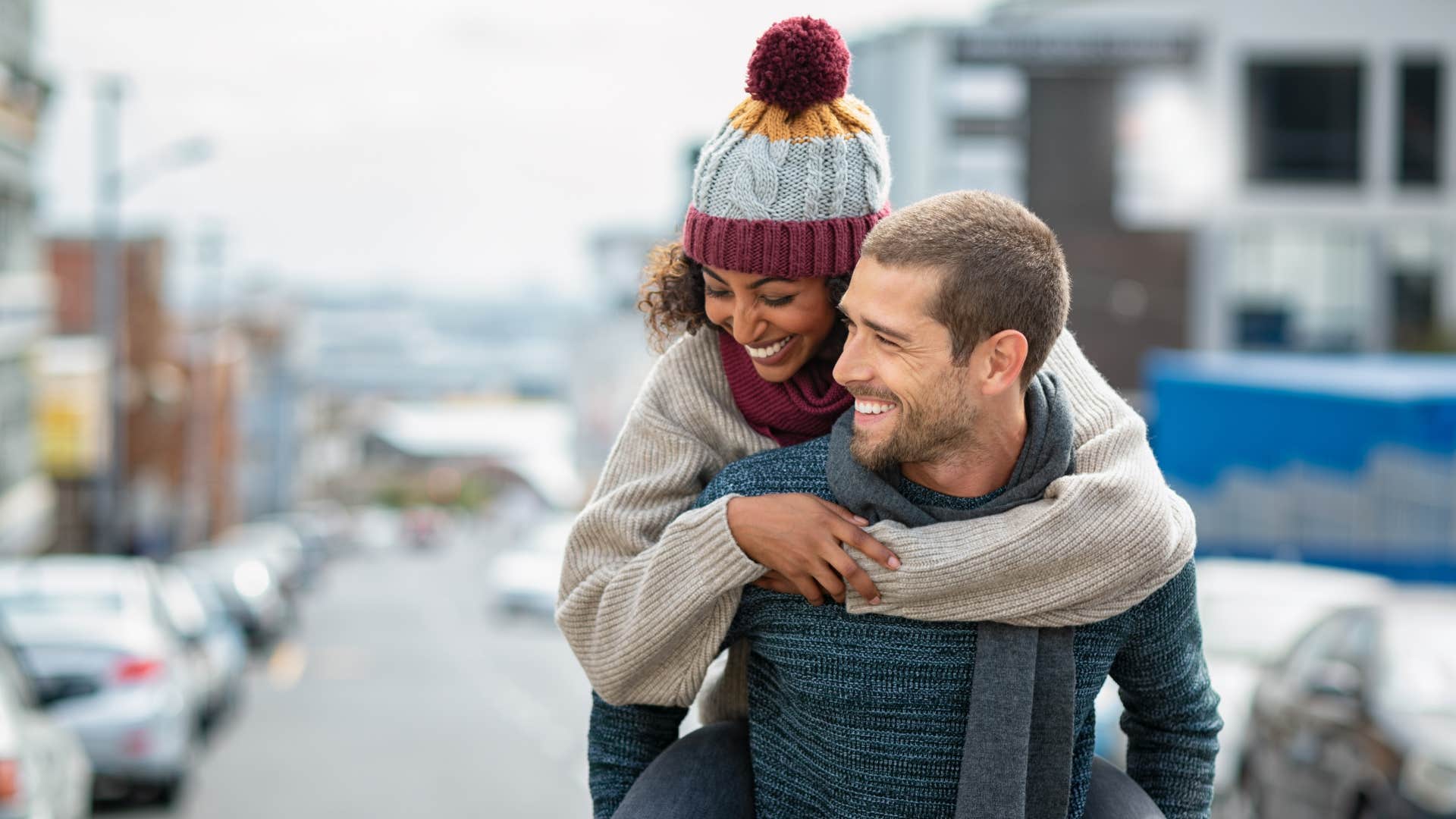 woman playing things chaotically fun as she hops on man's back