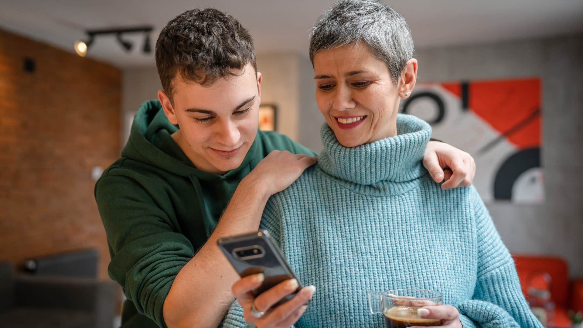 Teenage boy standing with his mom who brags about them more.