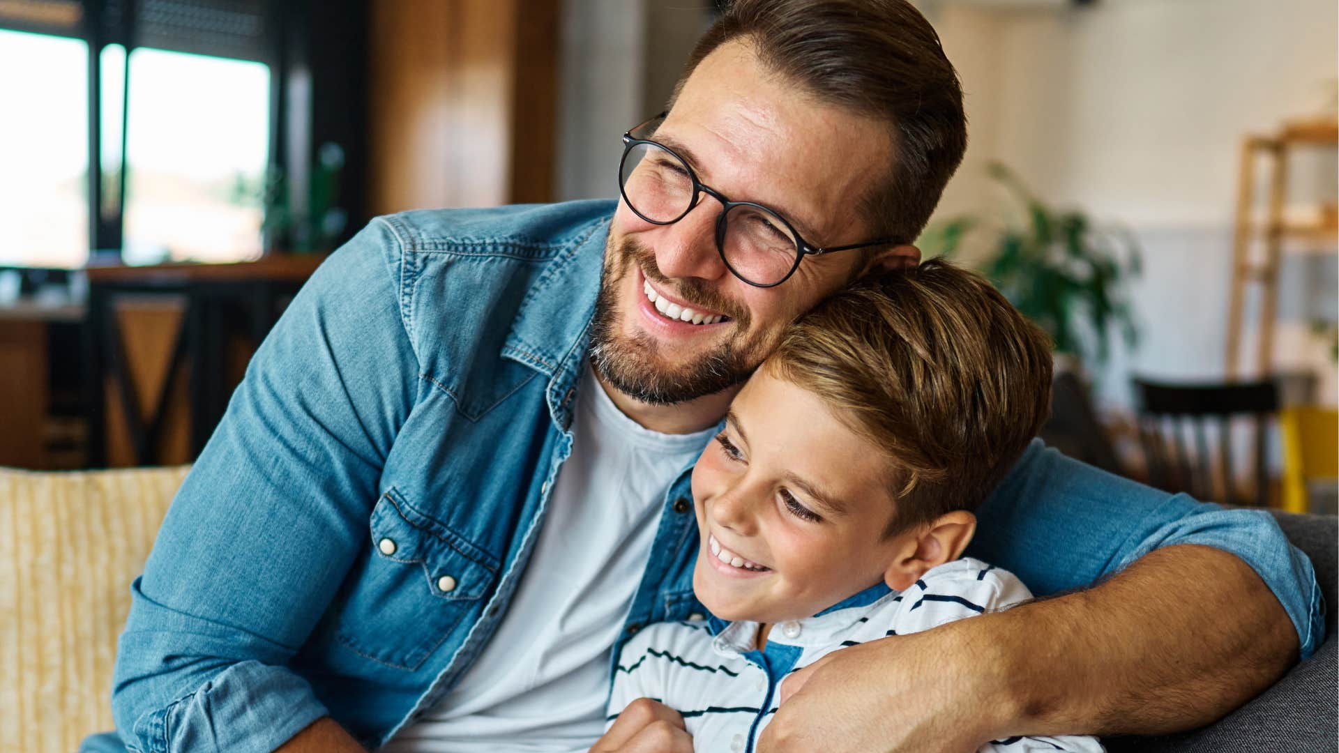Little boy hugging his dad who forgives them quicker.