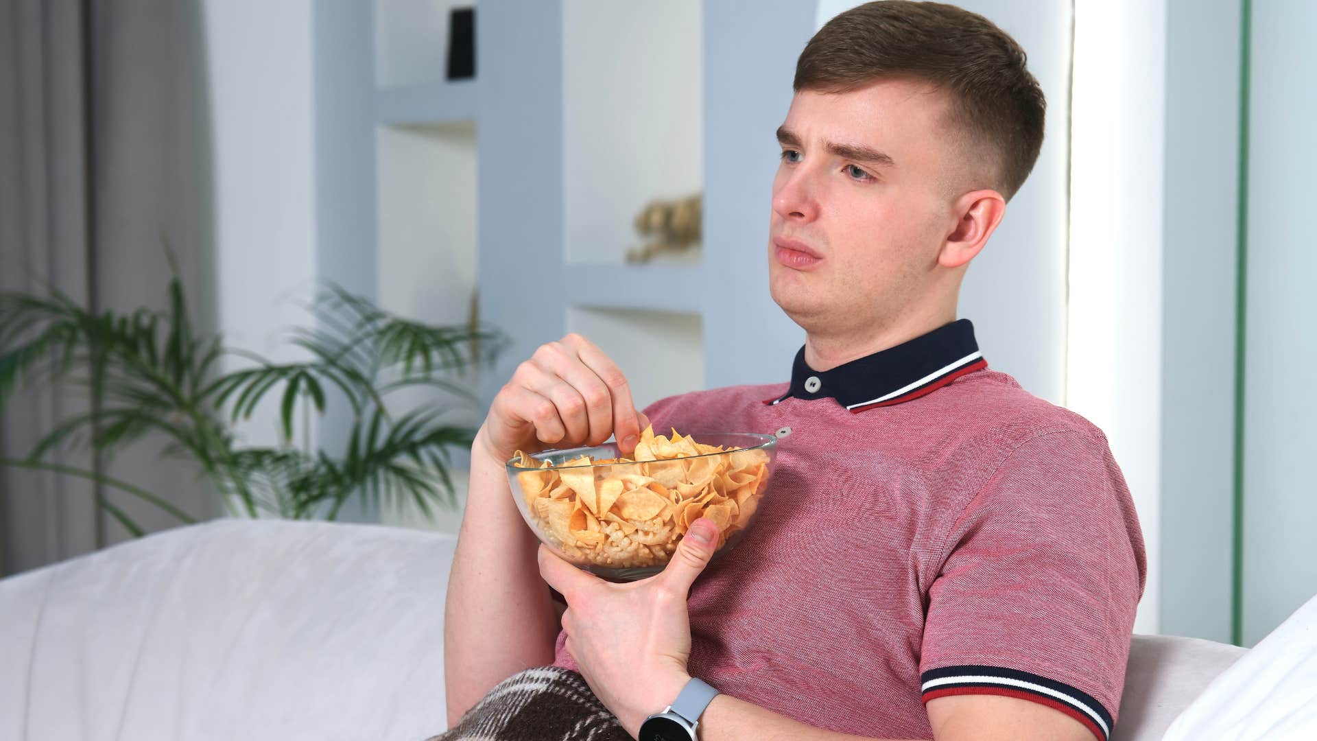 man eating unhealthy food on his couch