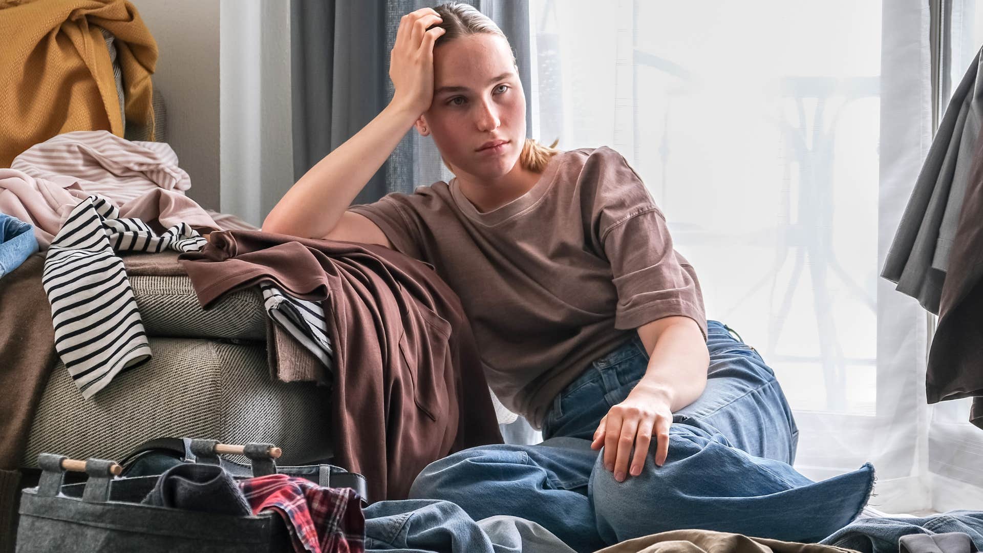 woman looking sad sitting with her clothes