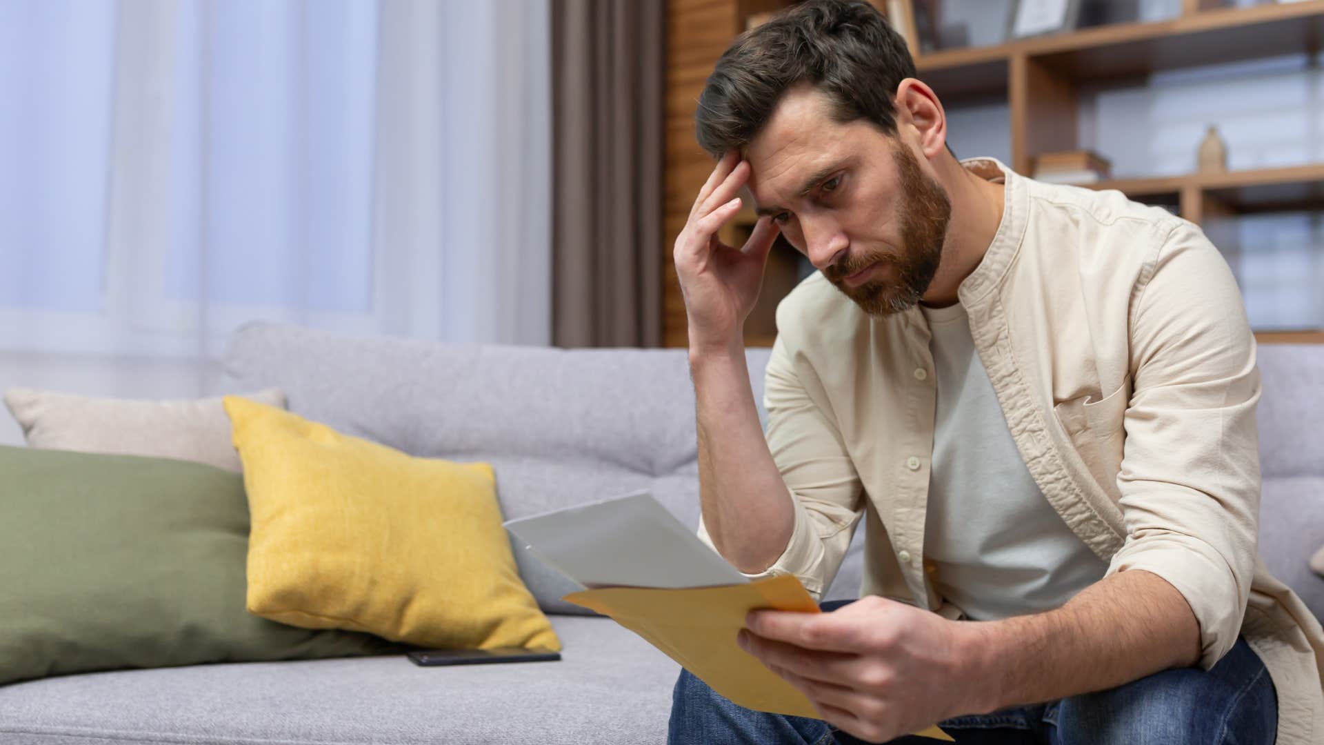 unhappy man looking at piles of unopened mail