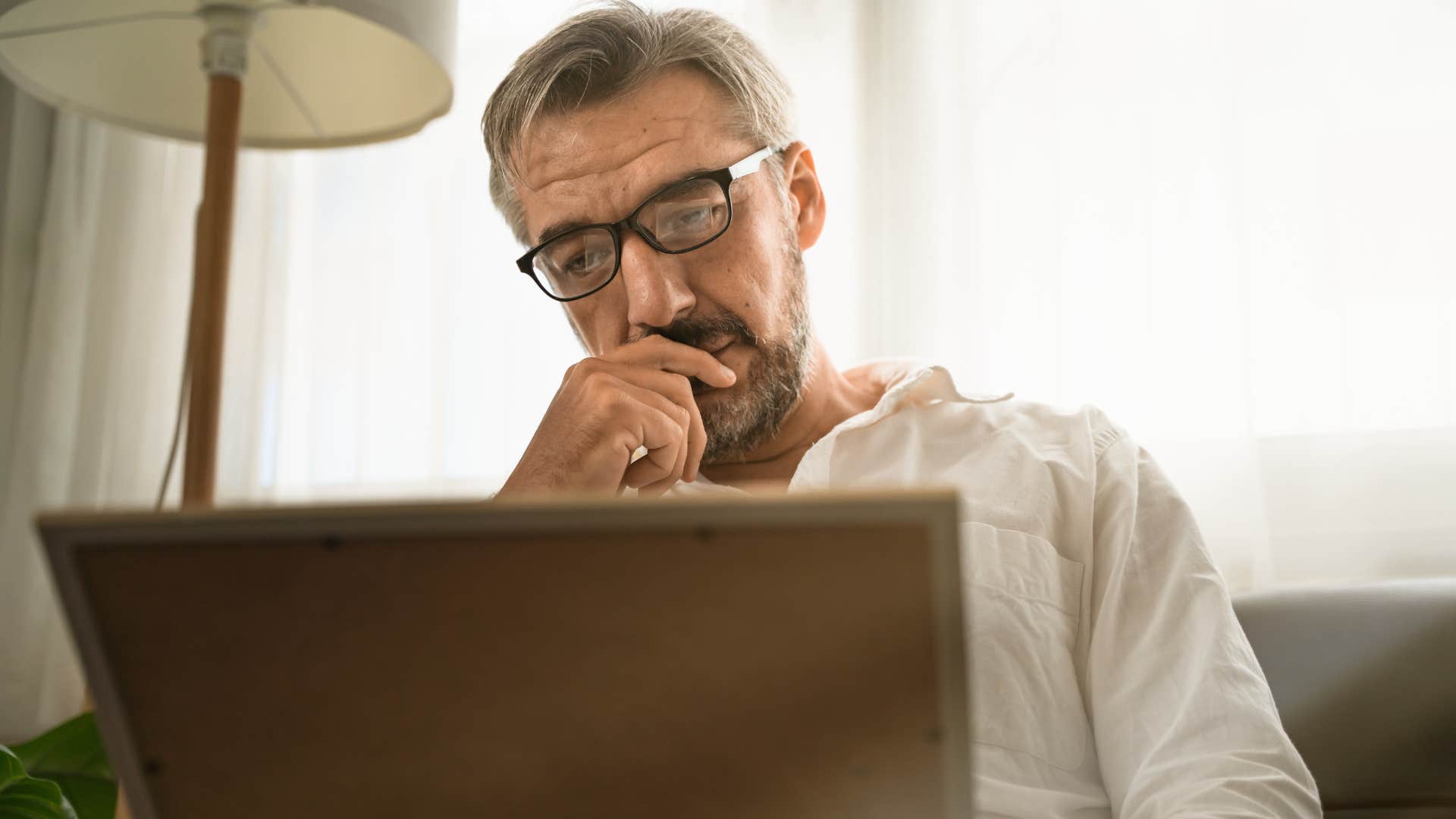 man looking at sentimental items with poor memories attached to them