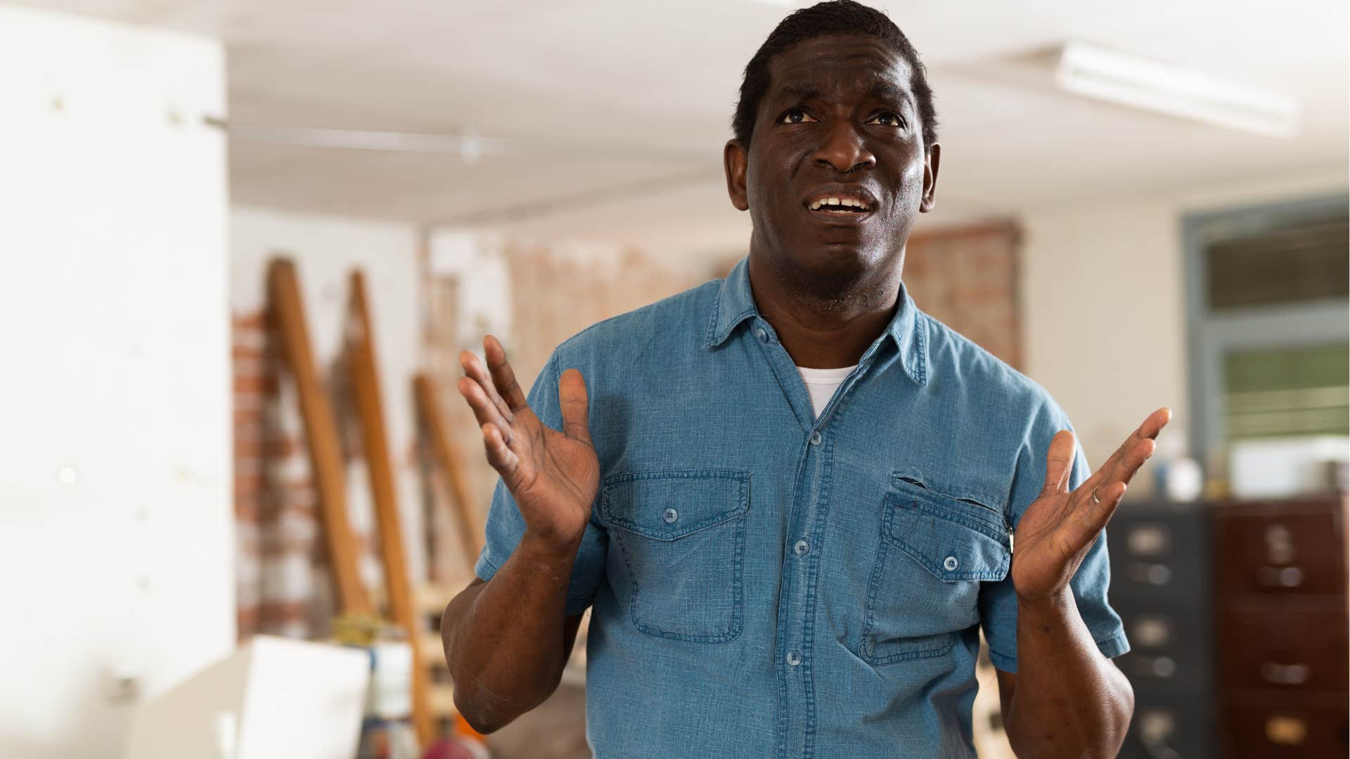 upset man surrounded by too much clutter at home