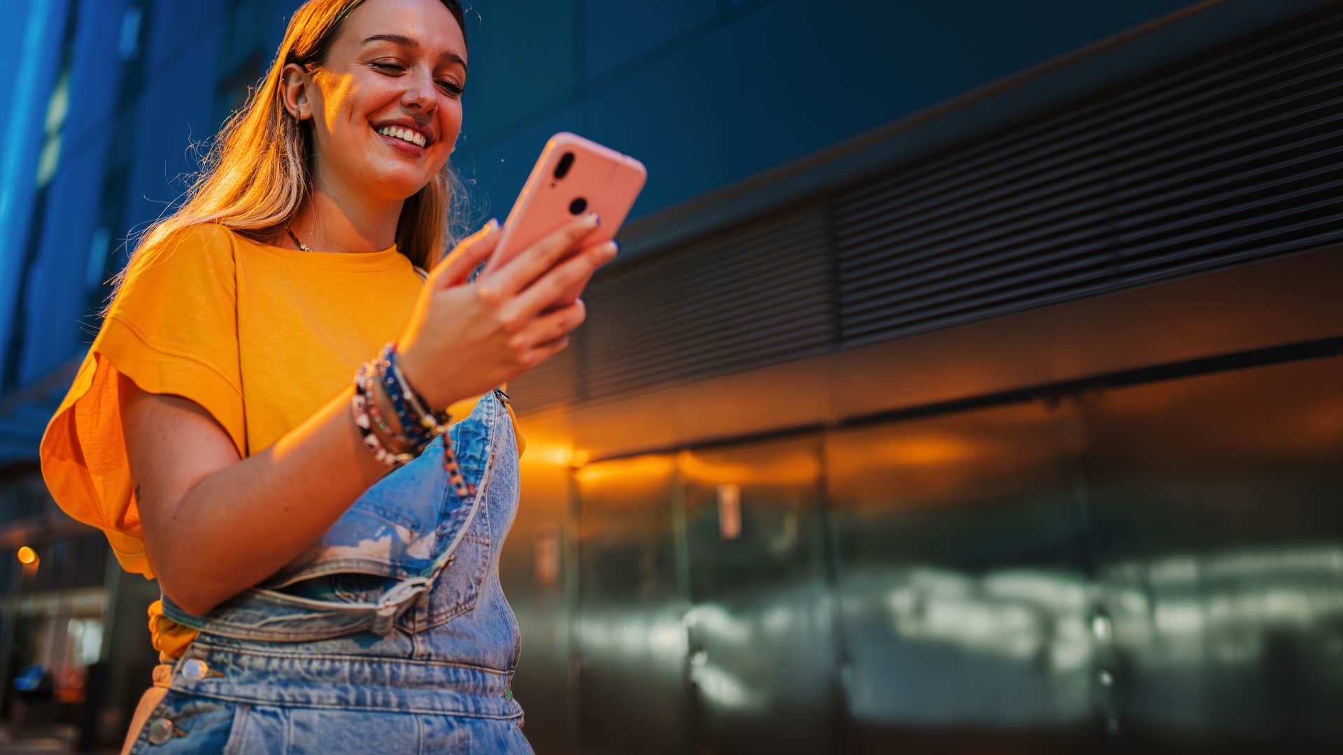 gen z woman using her phone while standing outside