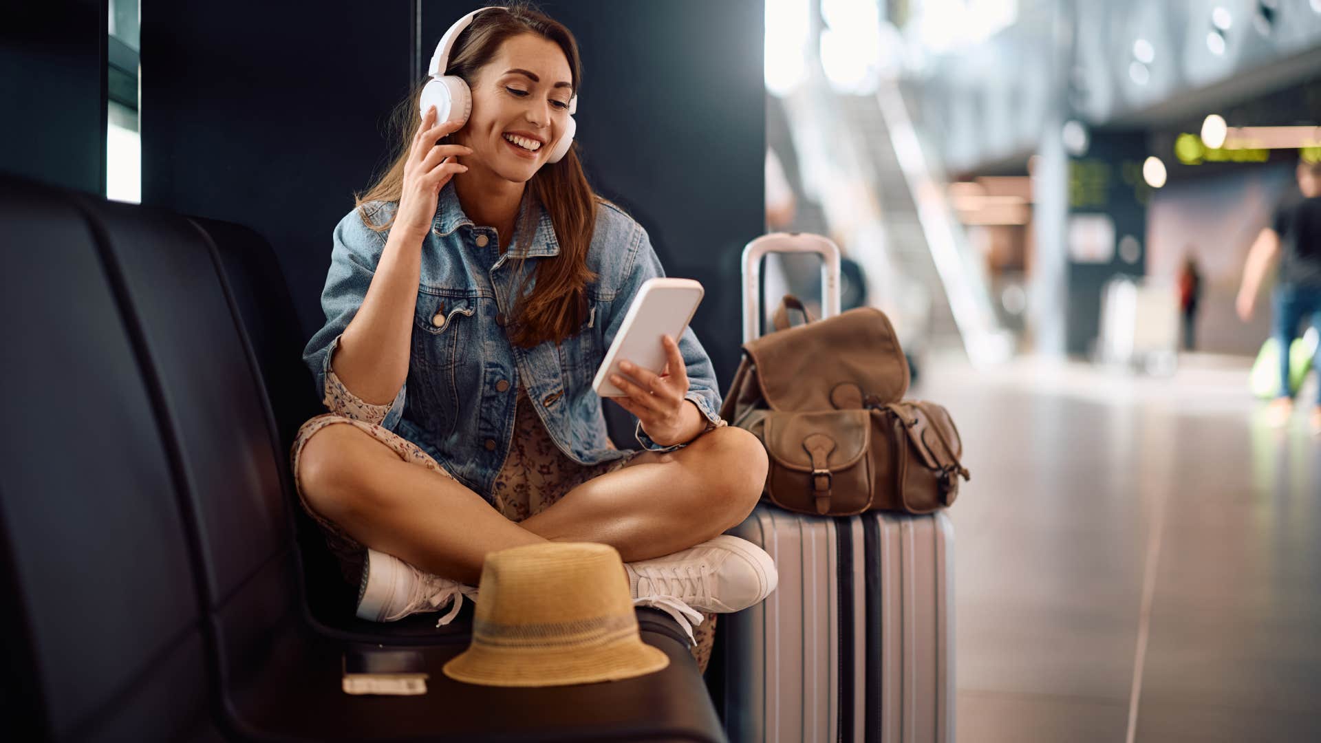 woman listening to podcast while sitting in airport