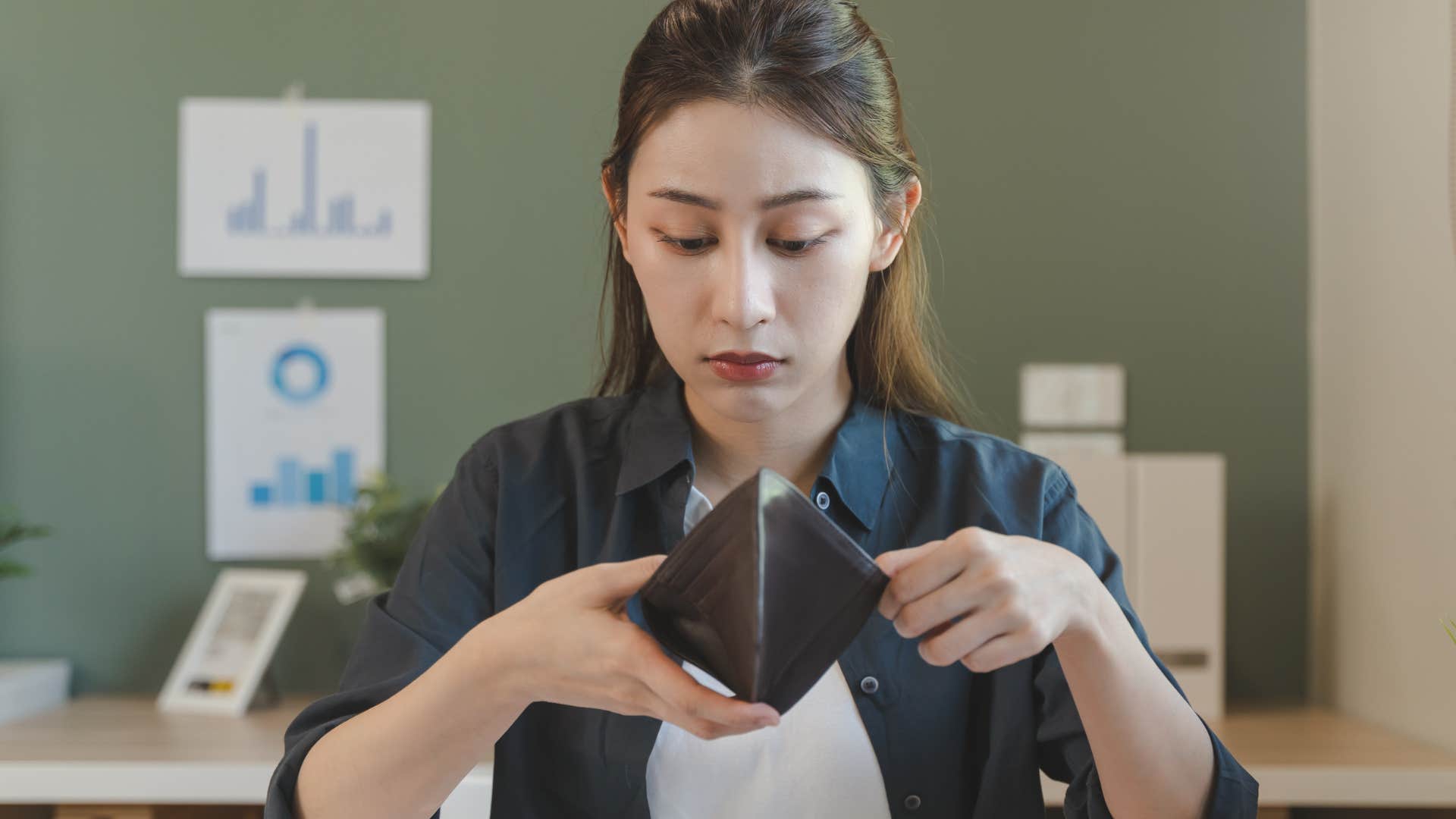 Sad woman saying "I've had a hard day" while looking in her wallet.