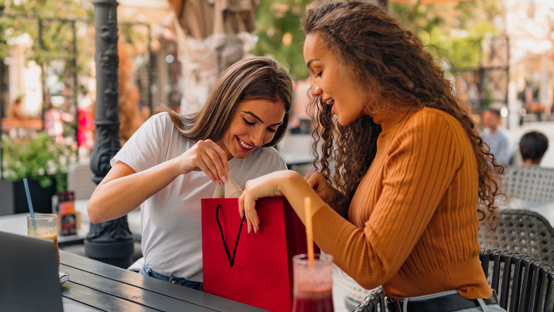 Woman showing her friend a bag and saying "it's retail therapy."