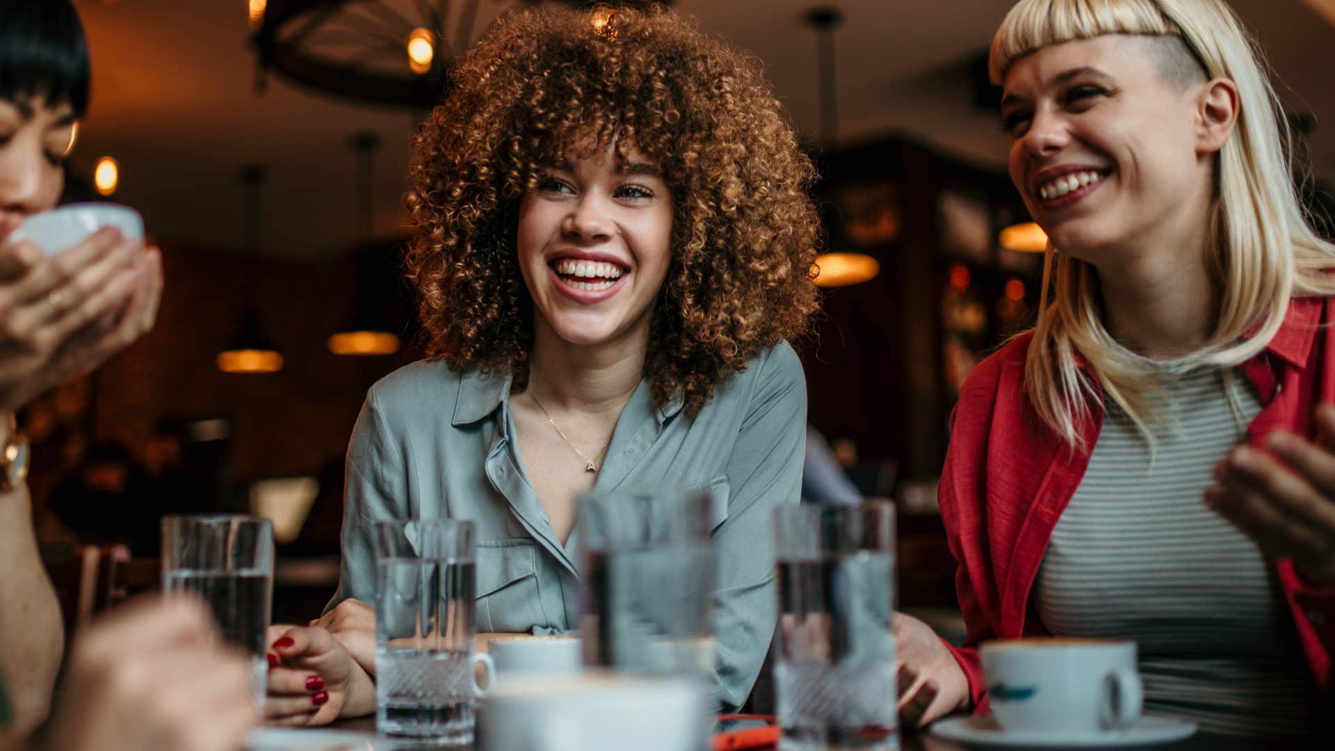 Woman who says "yes" to every social invitation smiling with friends.