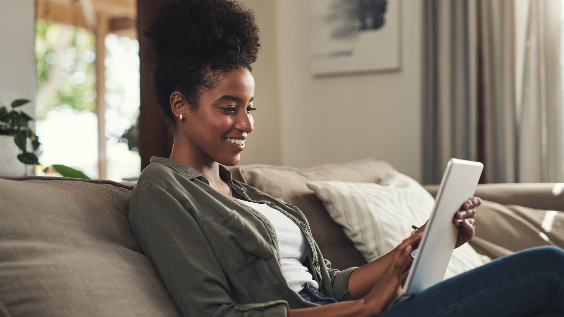 Woman impulsively online shopping on her couch.