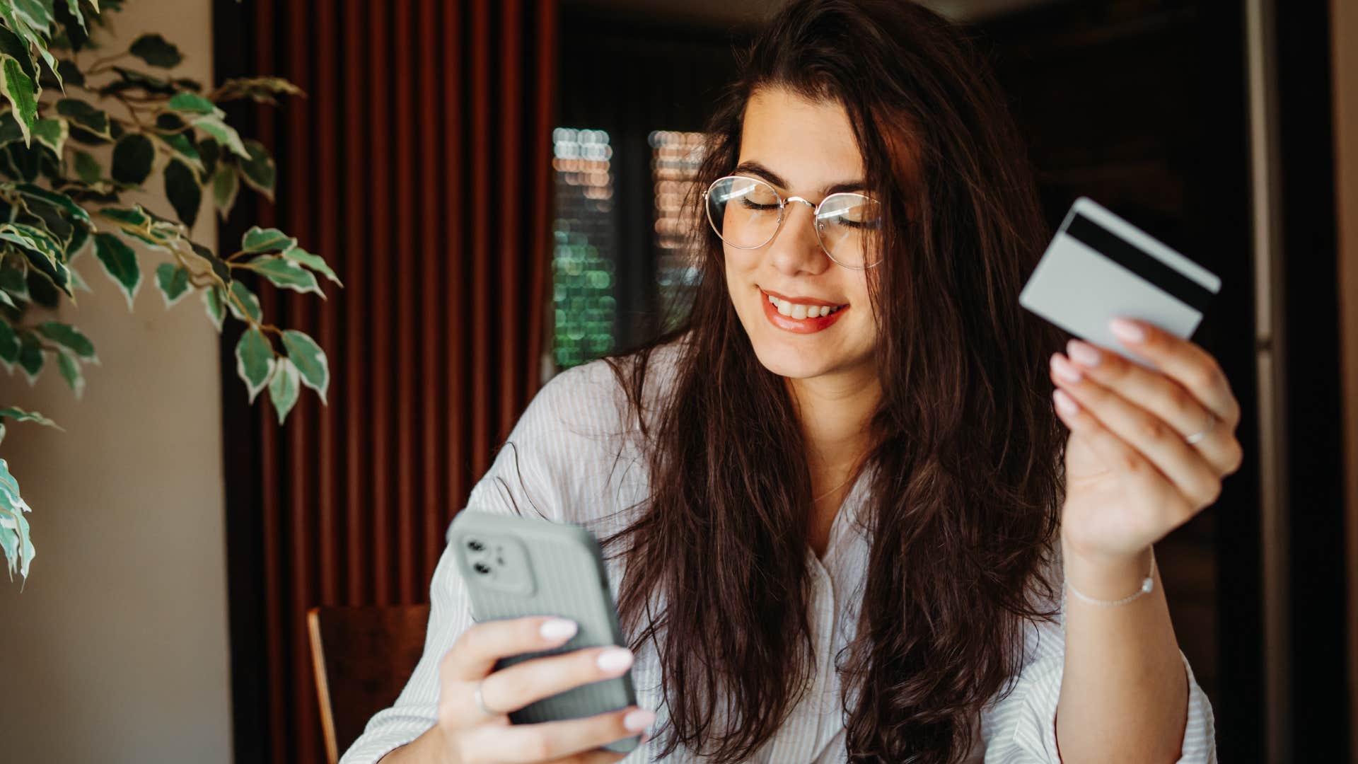 Woman opening and using credit cards at home.