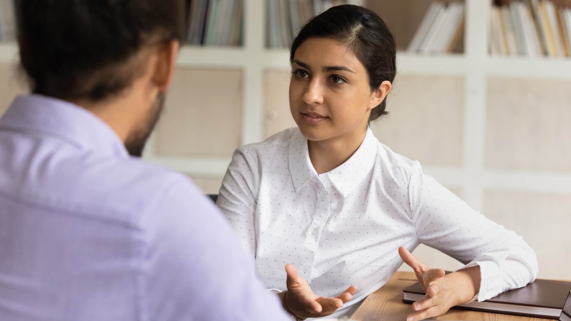 Woman saying "this isn't fair" to her co-worker.