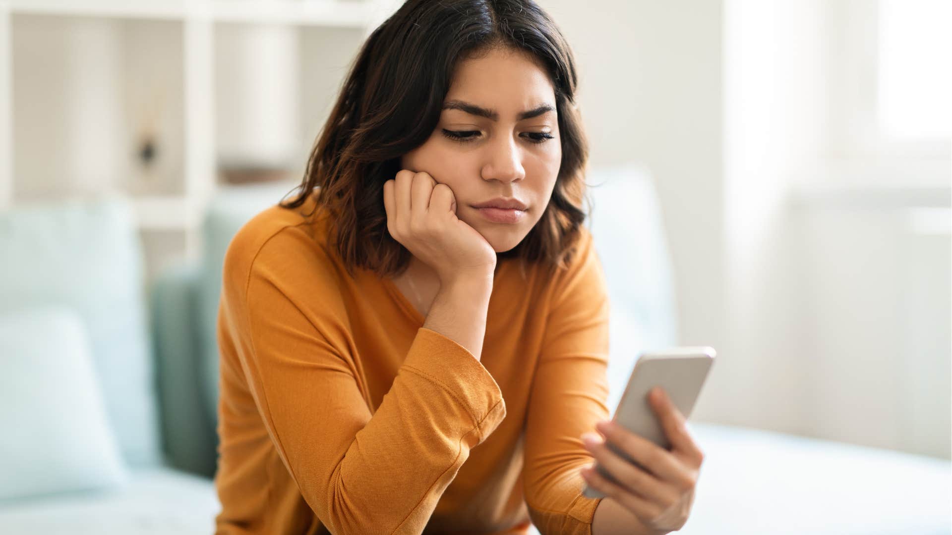 Woman who doesn't believe it changes anything looking at news on her phone.