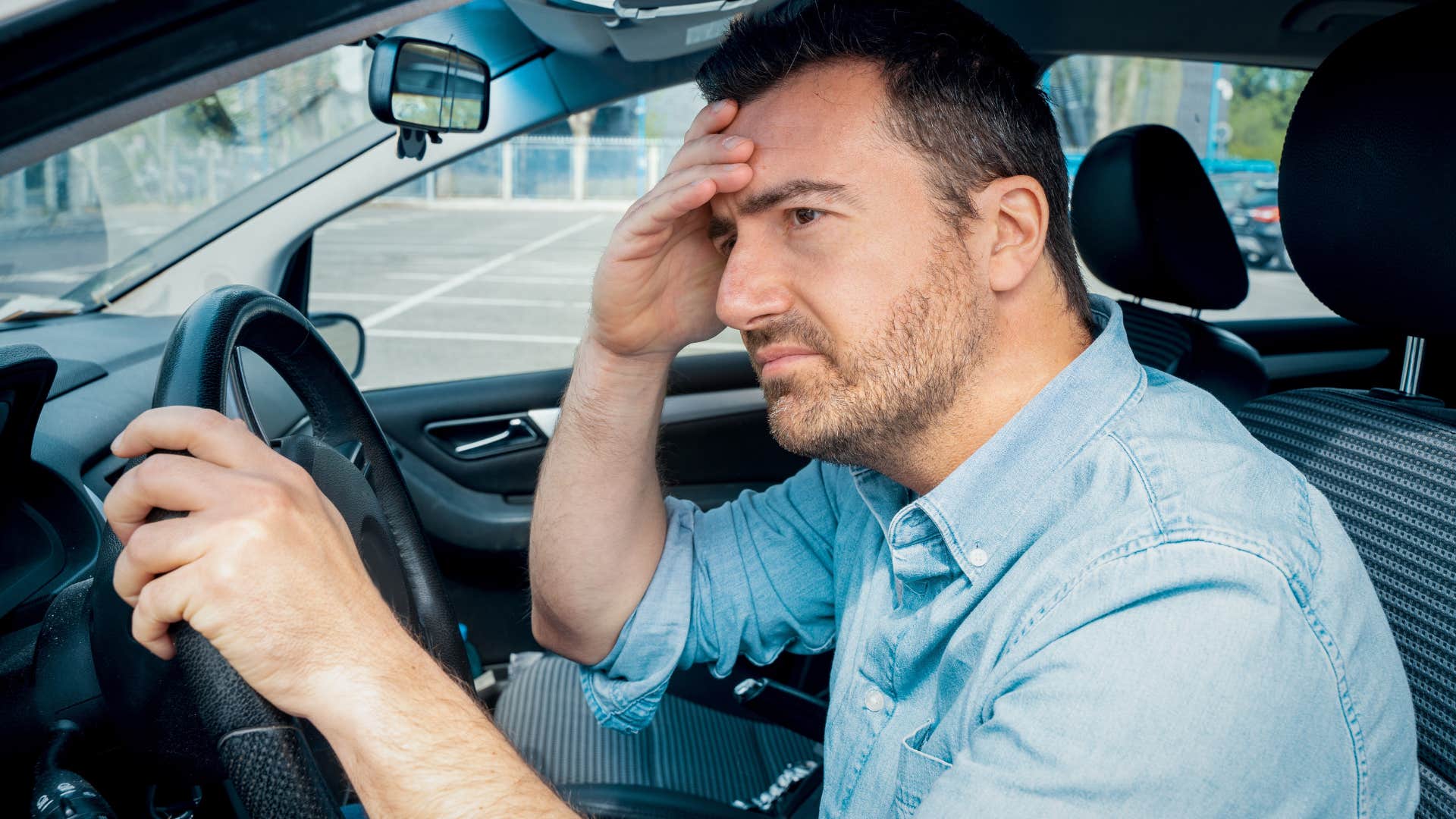 Man feeling guilty while driving in his car.