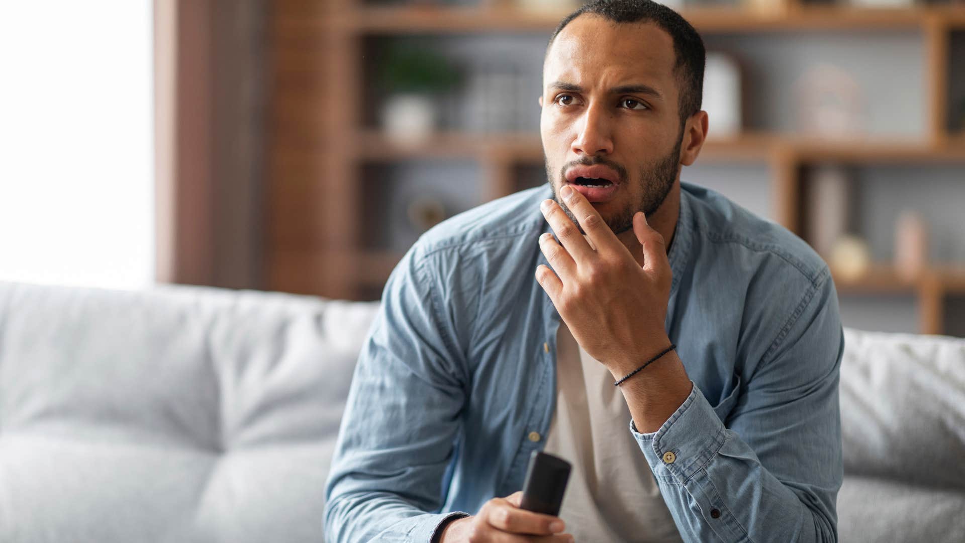 Man thinking nothing feels clear while watching TV.