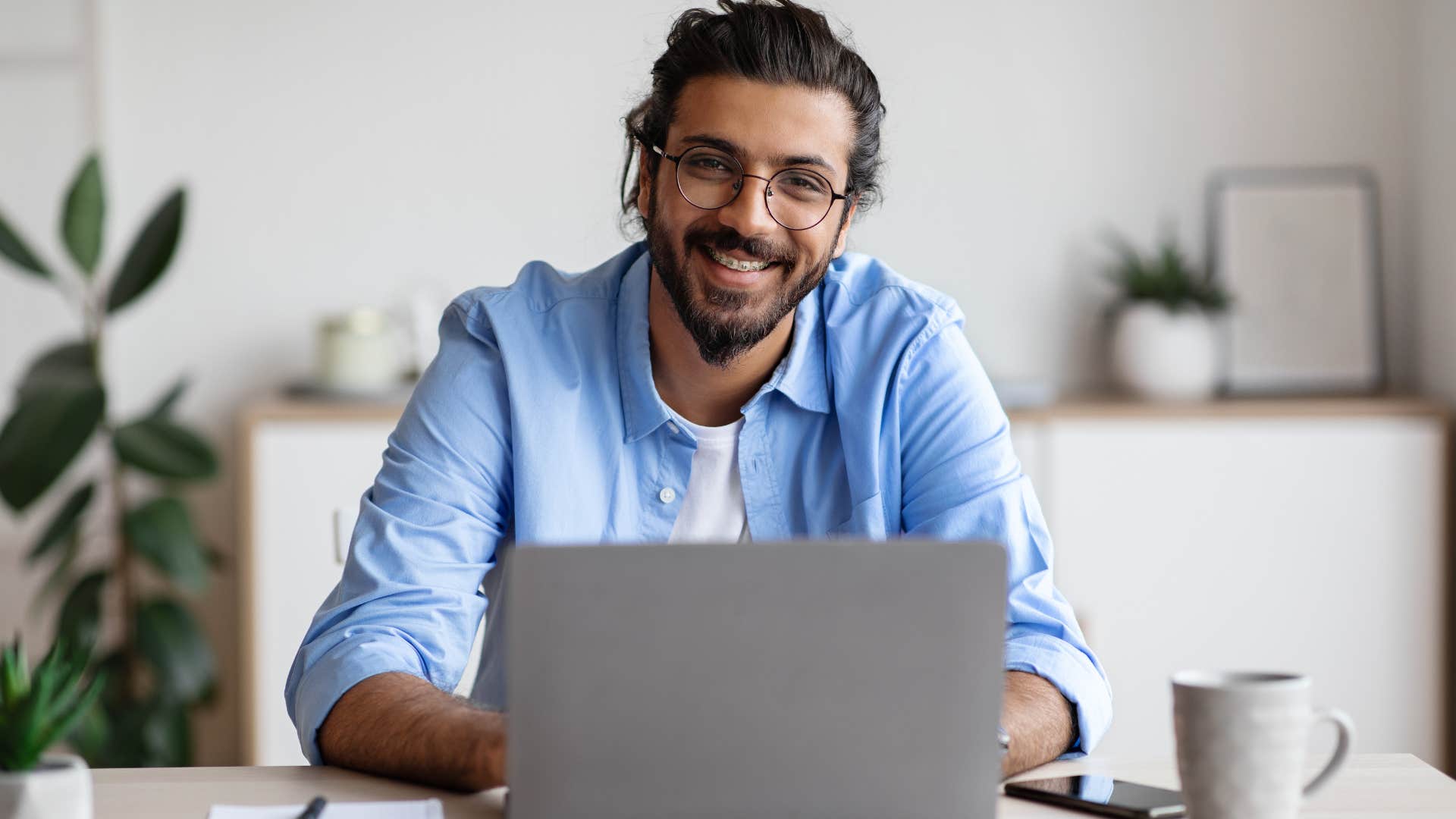 man following societal norms working on his laptop