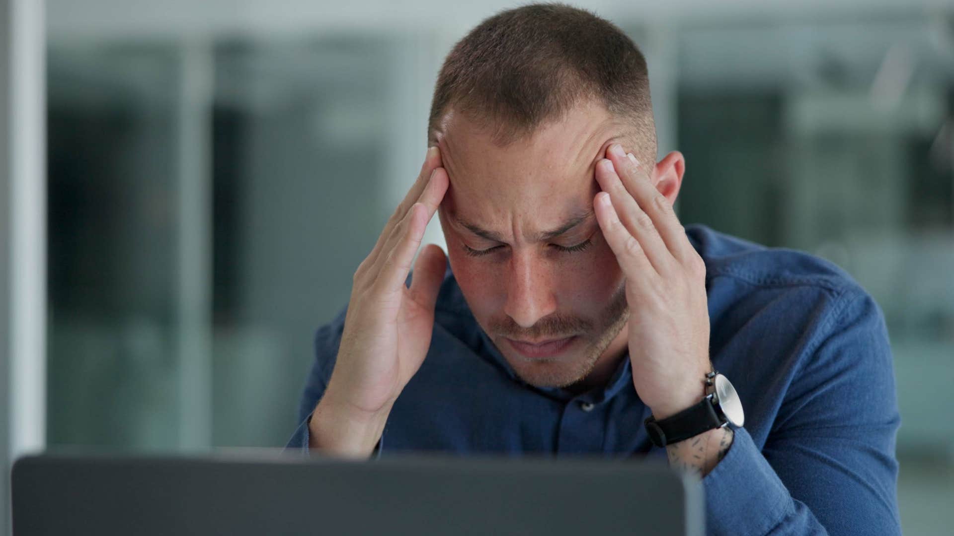 stressed man staying busy 24/7 holding his head