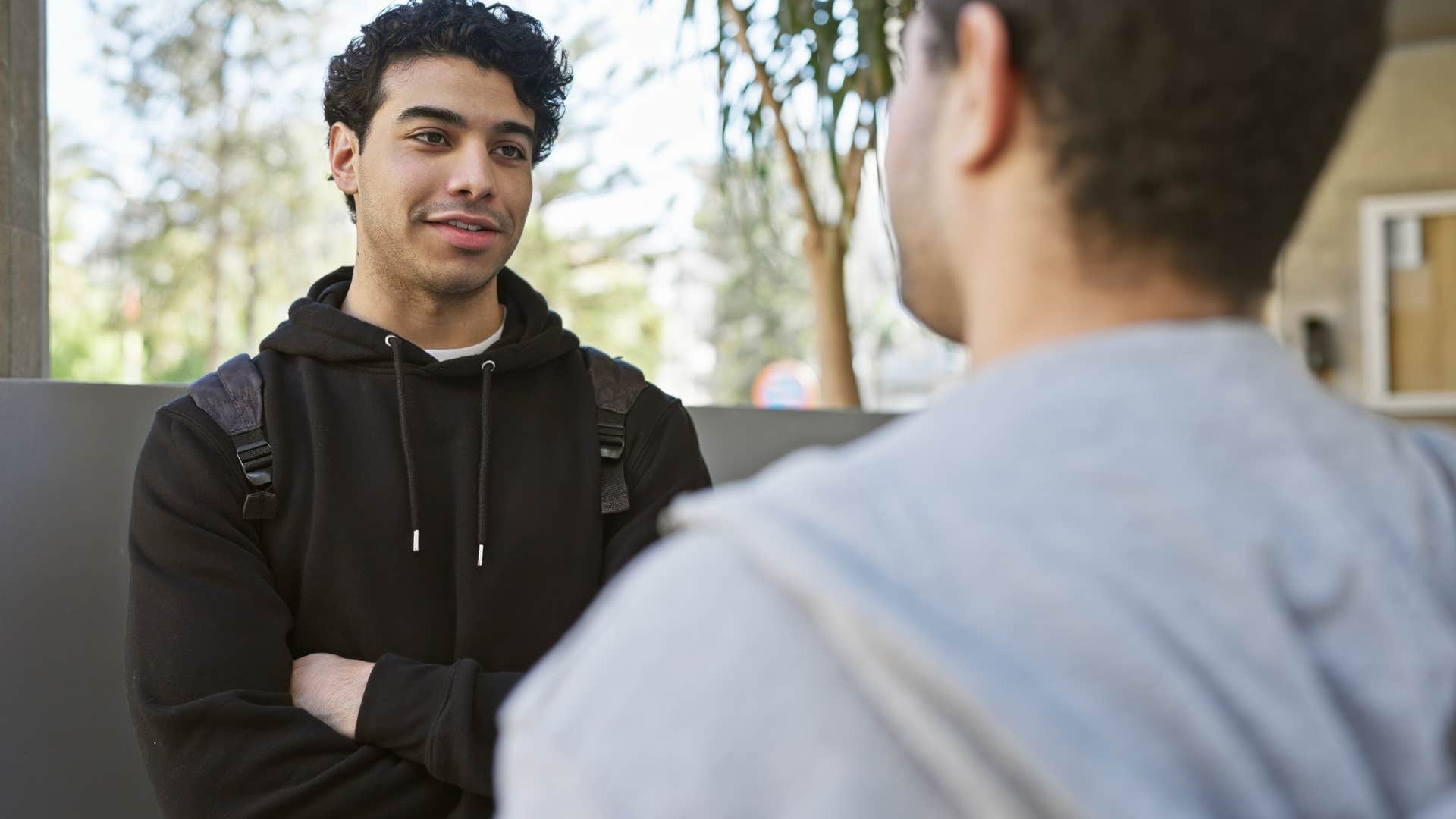 man thinking YOLO while talking to a friend