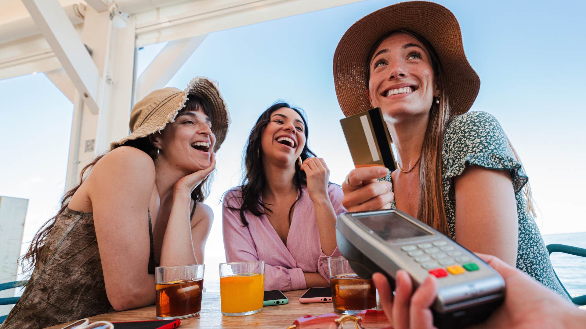 women paying at a restaurant living too far in the present moment