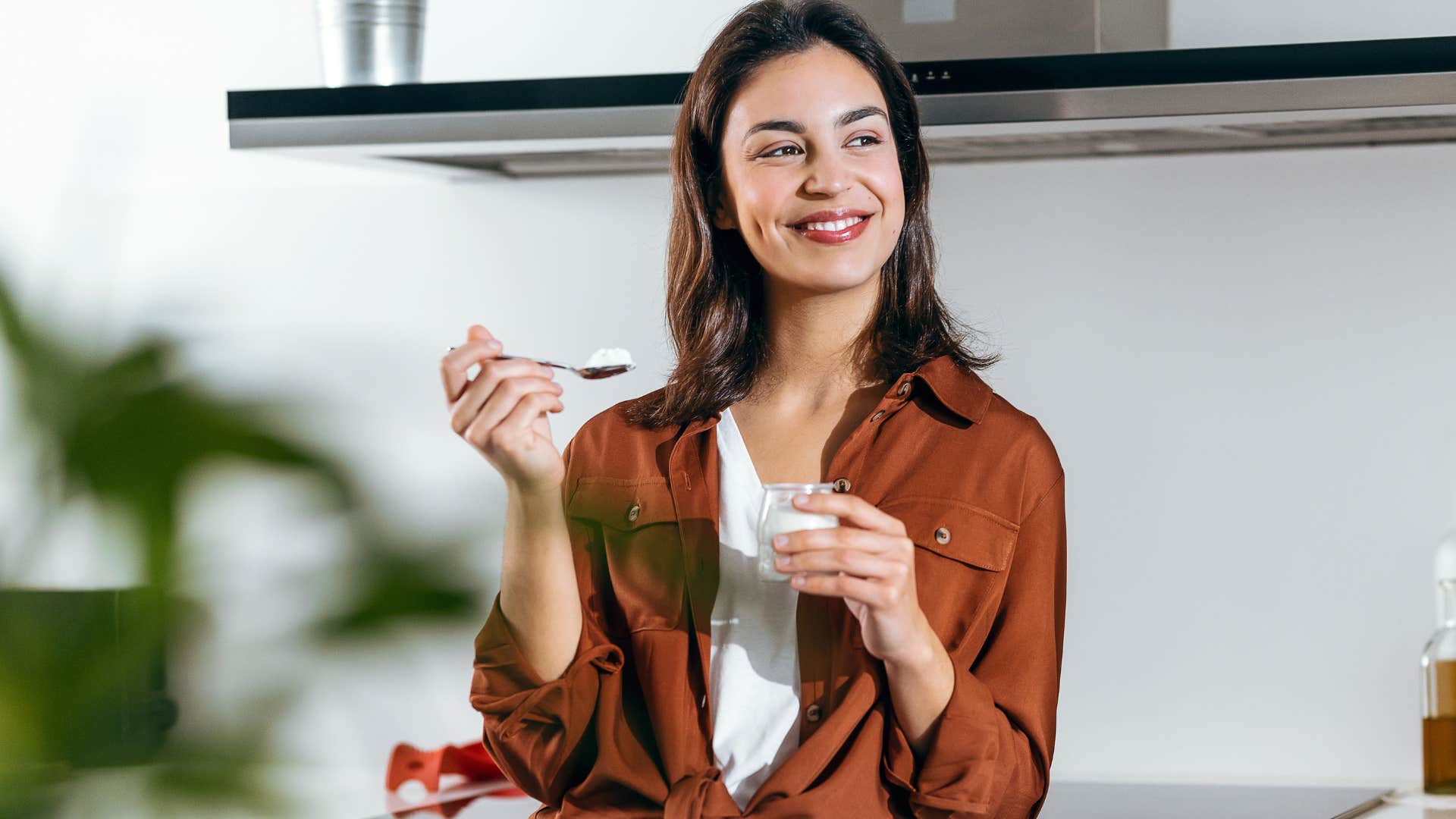Woman eating brand-name options in her kitchen.