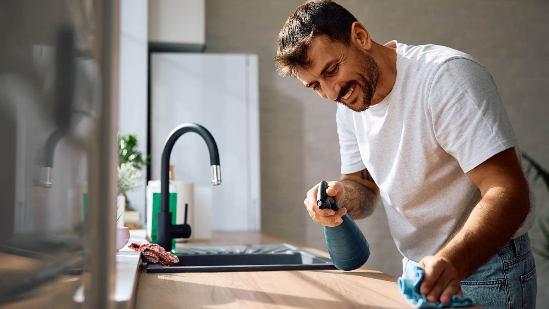 Man using specific cleaning supplies in his kitchen.