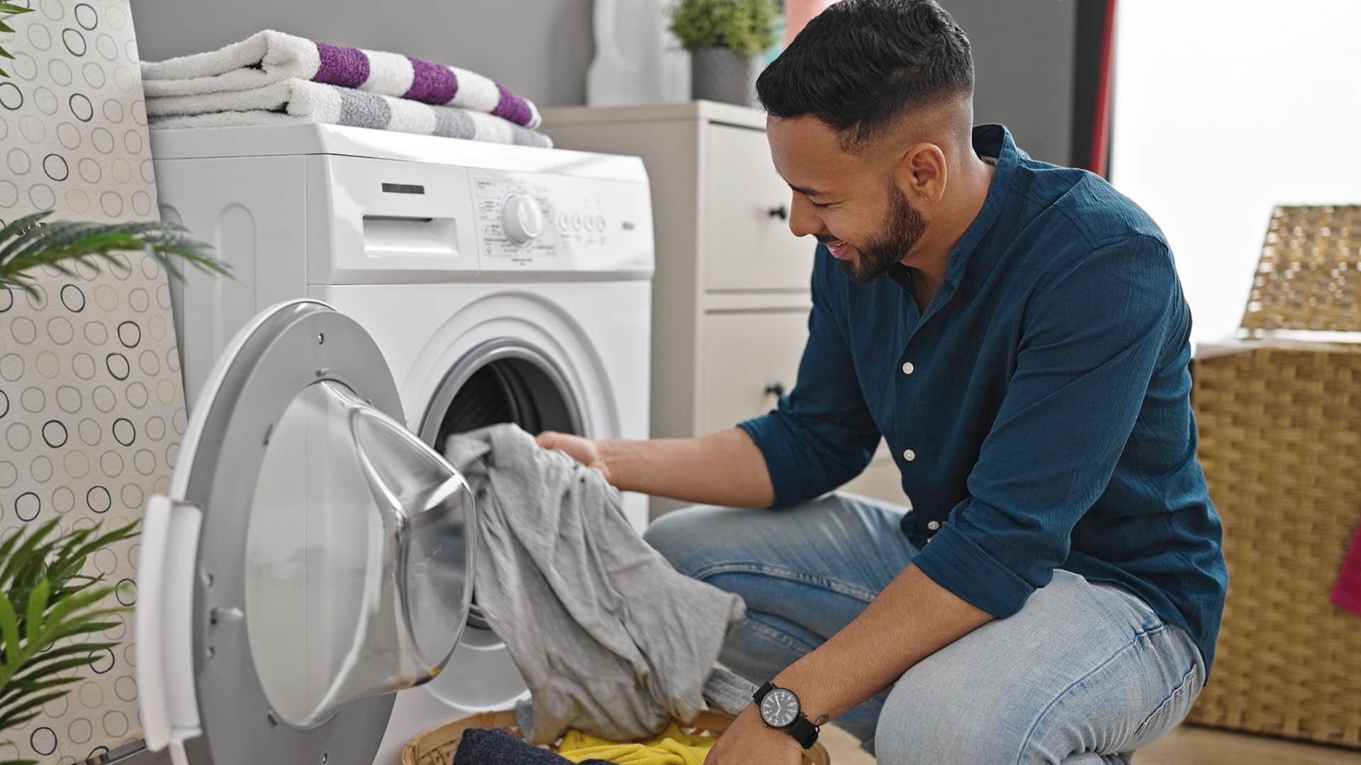 Man doing laundry with working appliances at home.