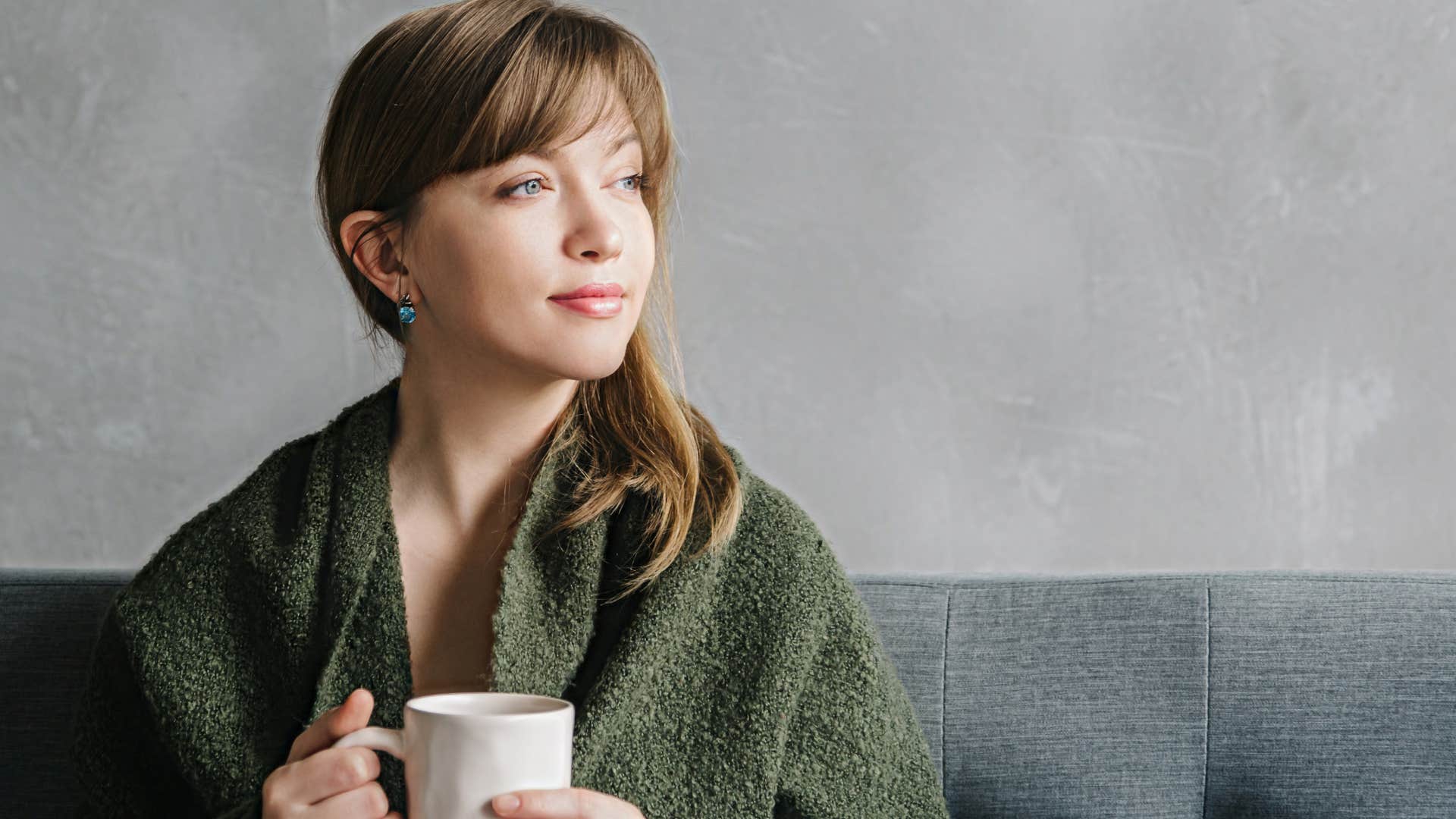 woman sitting on the couch thinking about quality versus quantity in home