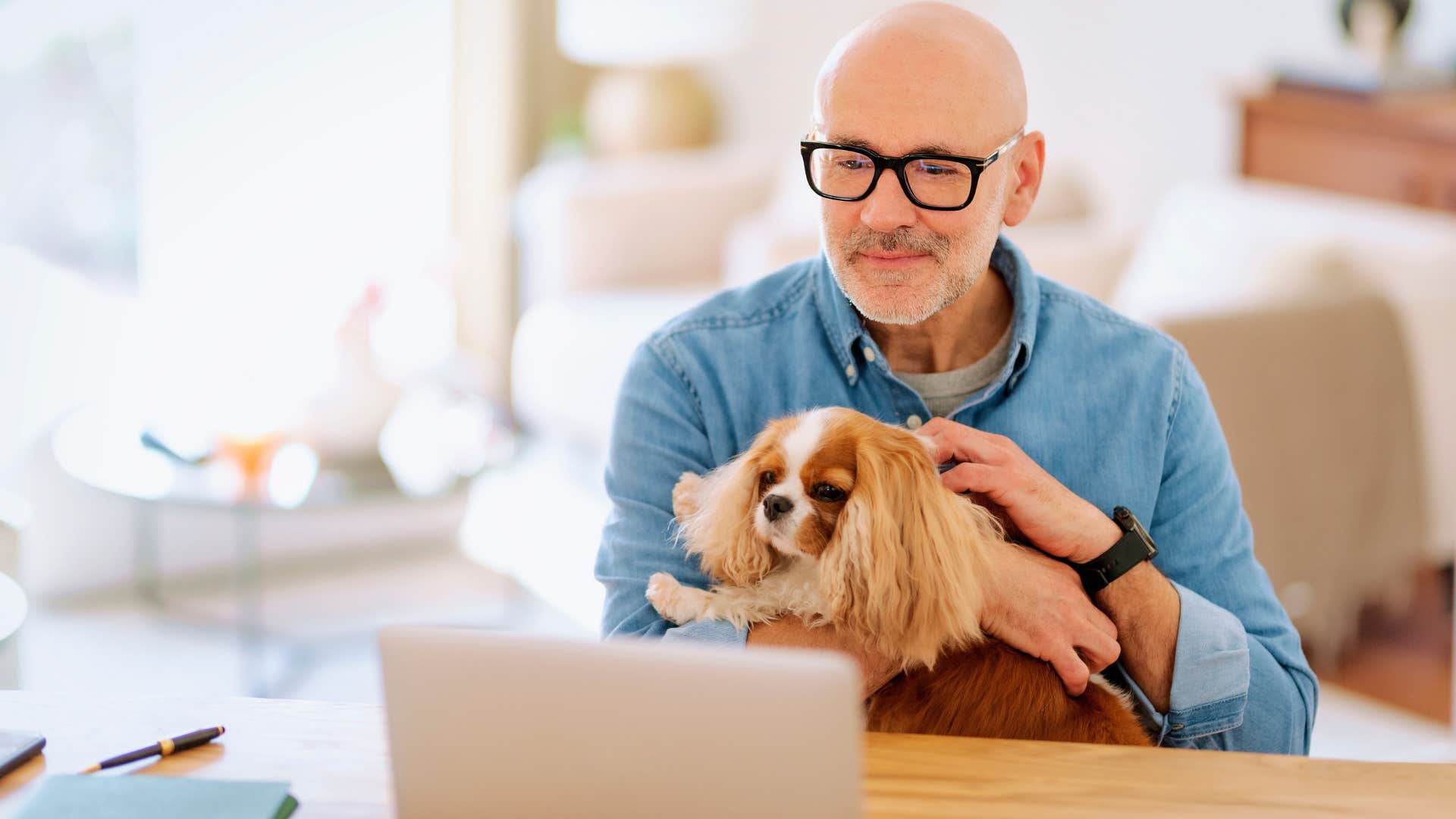 man doing work and sitting with his loyal dog