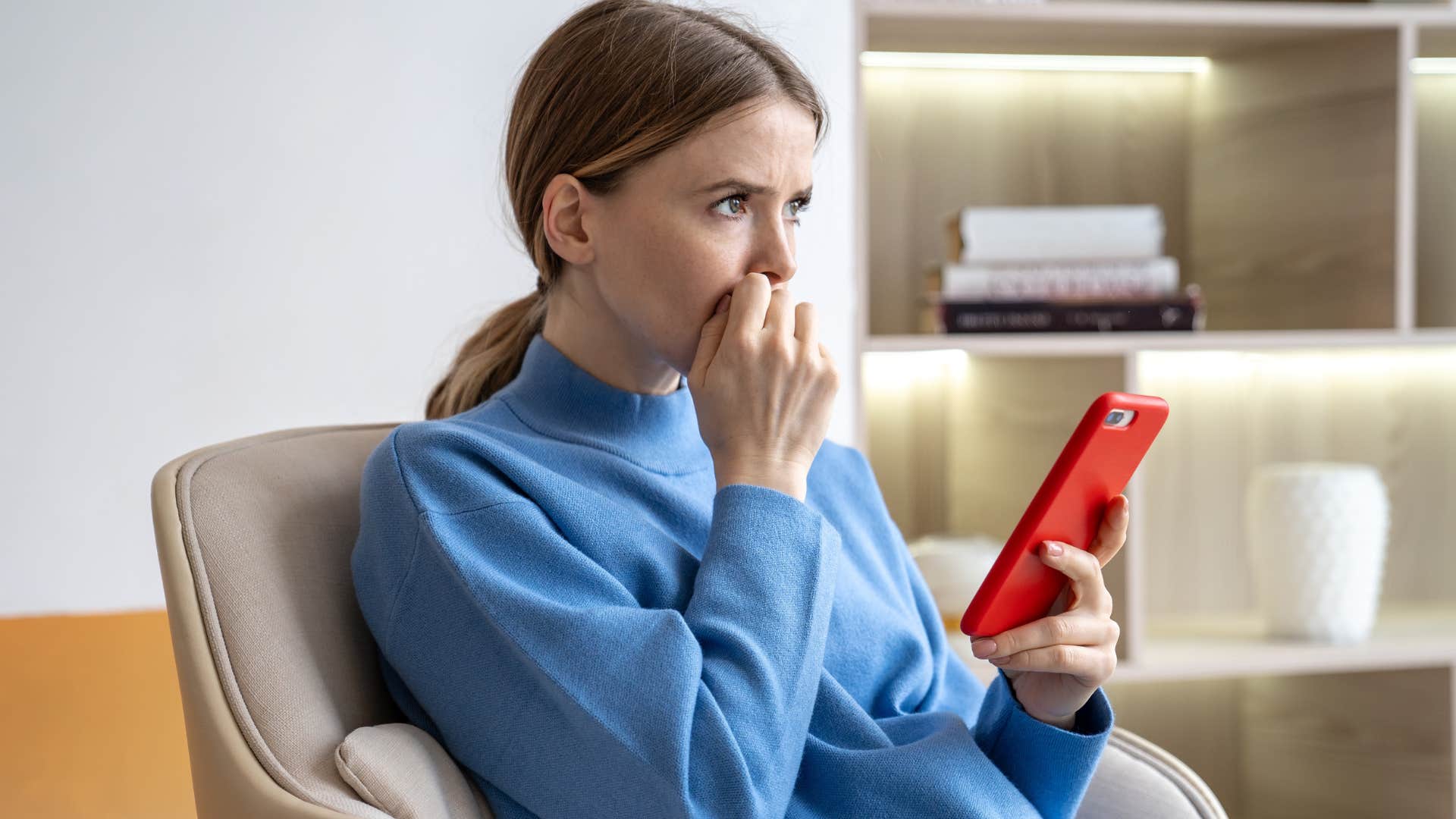 Woman looking at conspiracy theories on her phone.
