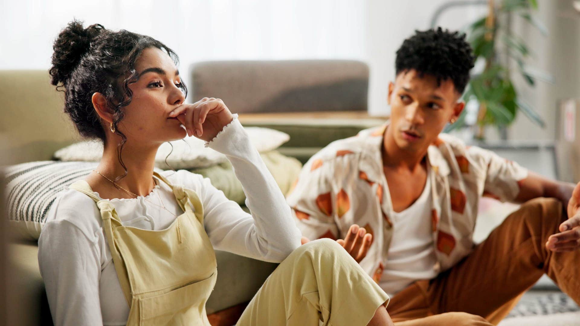 married couple having conversation on floor of room