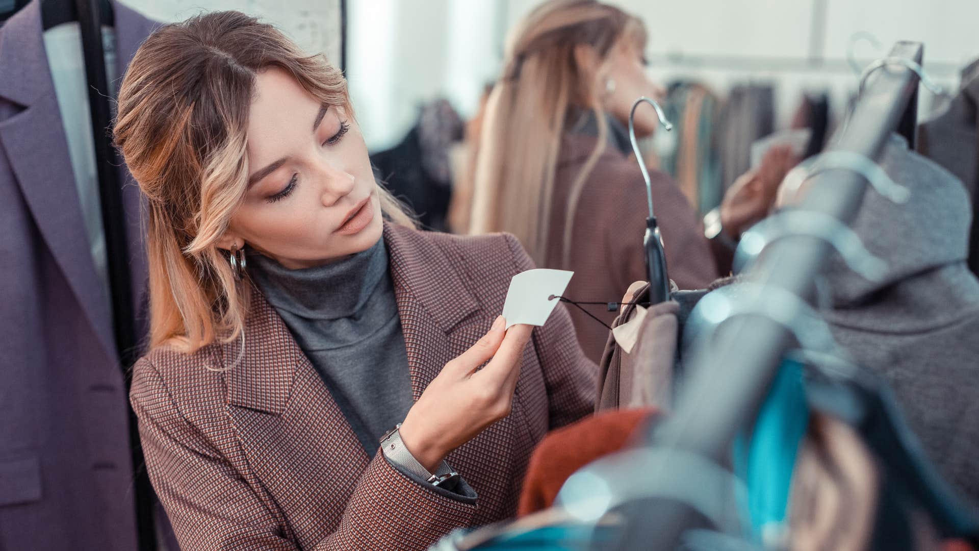 woman looking at clothes thinking she cant afford it