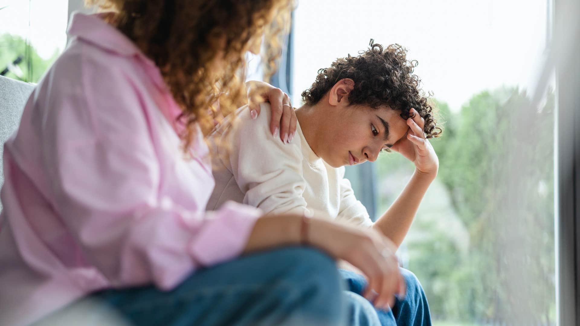 upset teenage boy refusing to talk to parent
