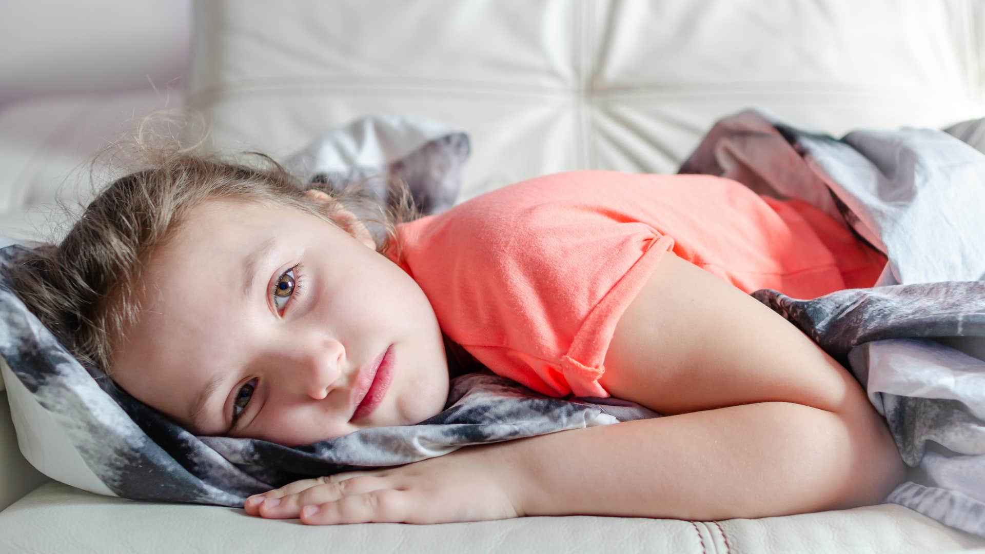 little girl feeling lost and lying on bed
