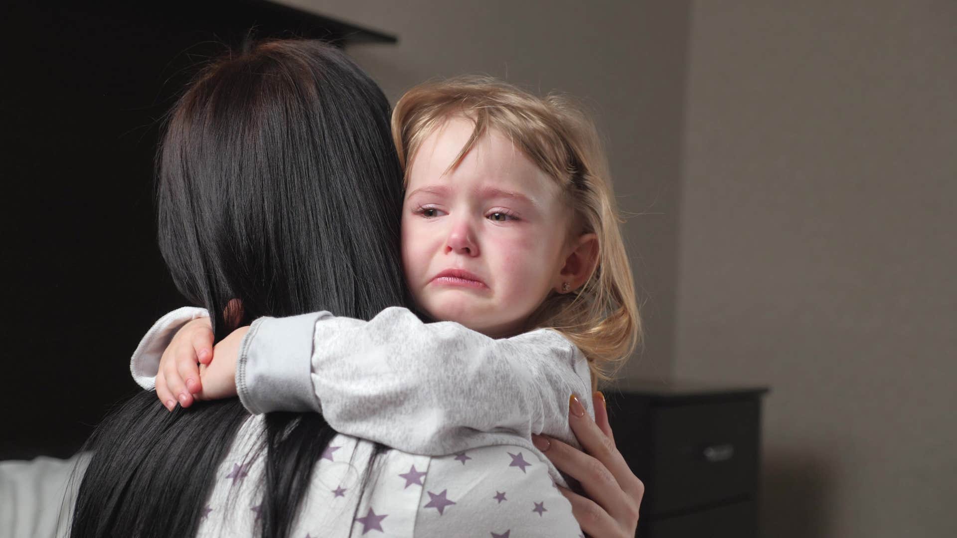 little girl crying on mom's shoulder thinking it's my fault
