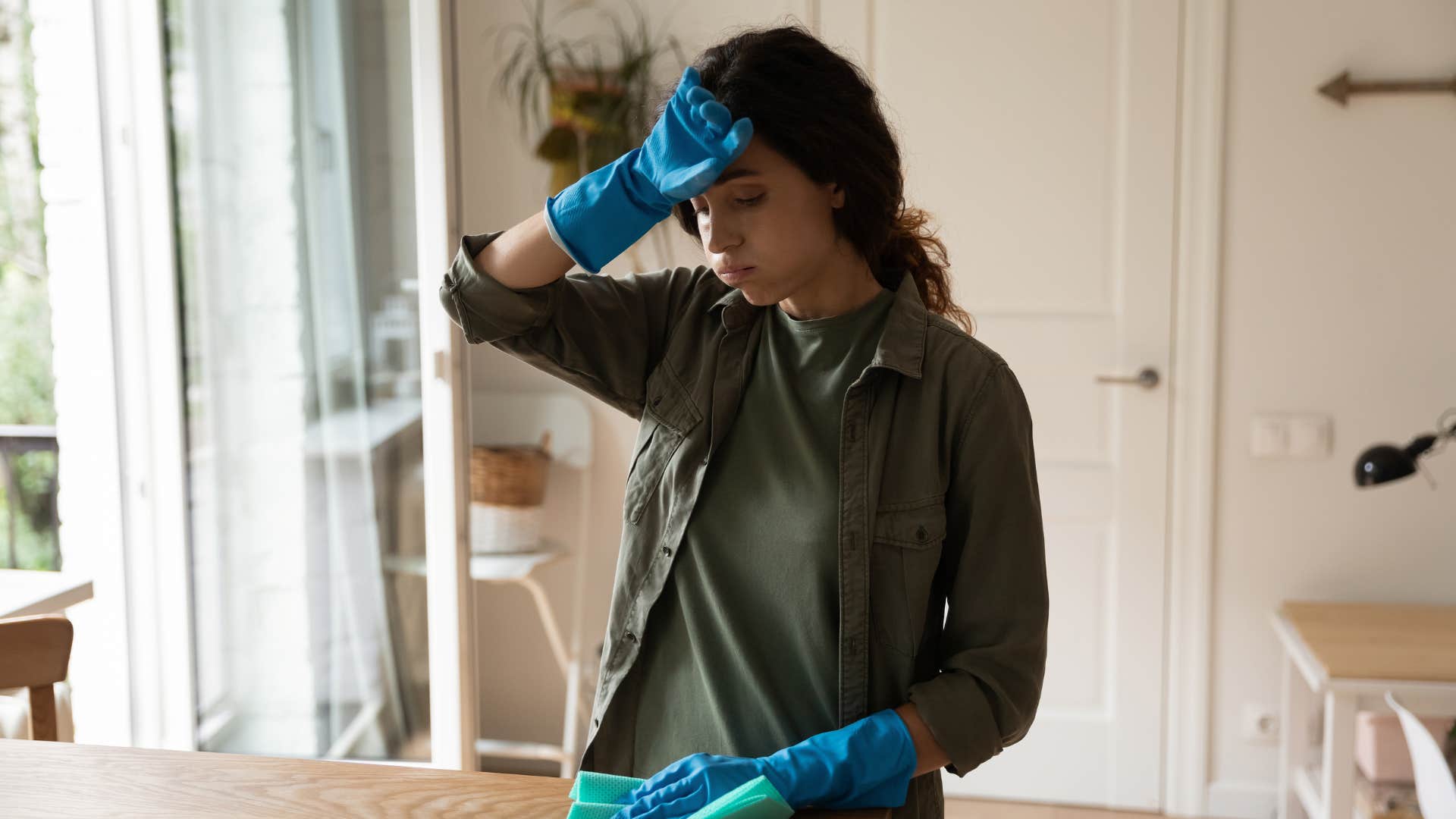 woman in green brushing off forehead as she says i'll do it myself