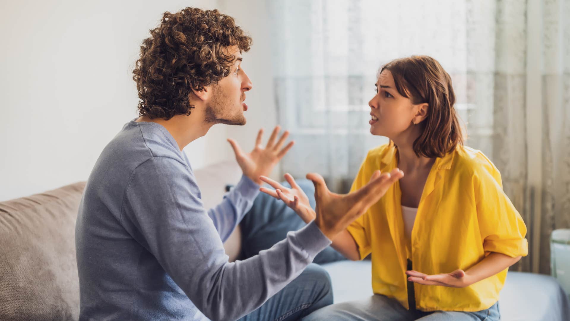 woman in yellow telling man you need to man up as they argue