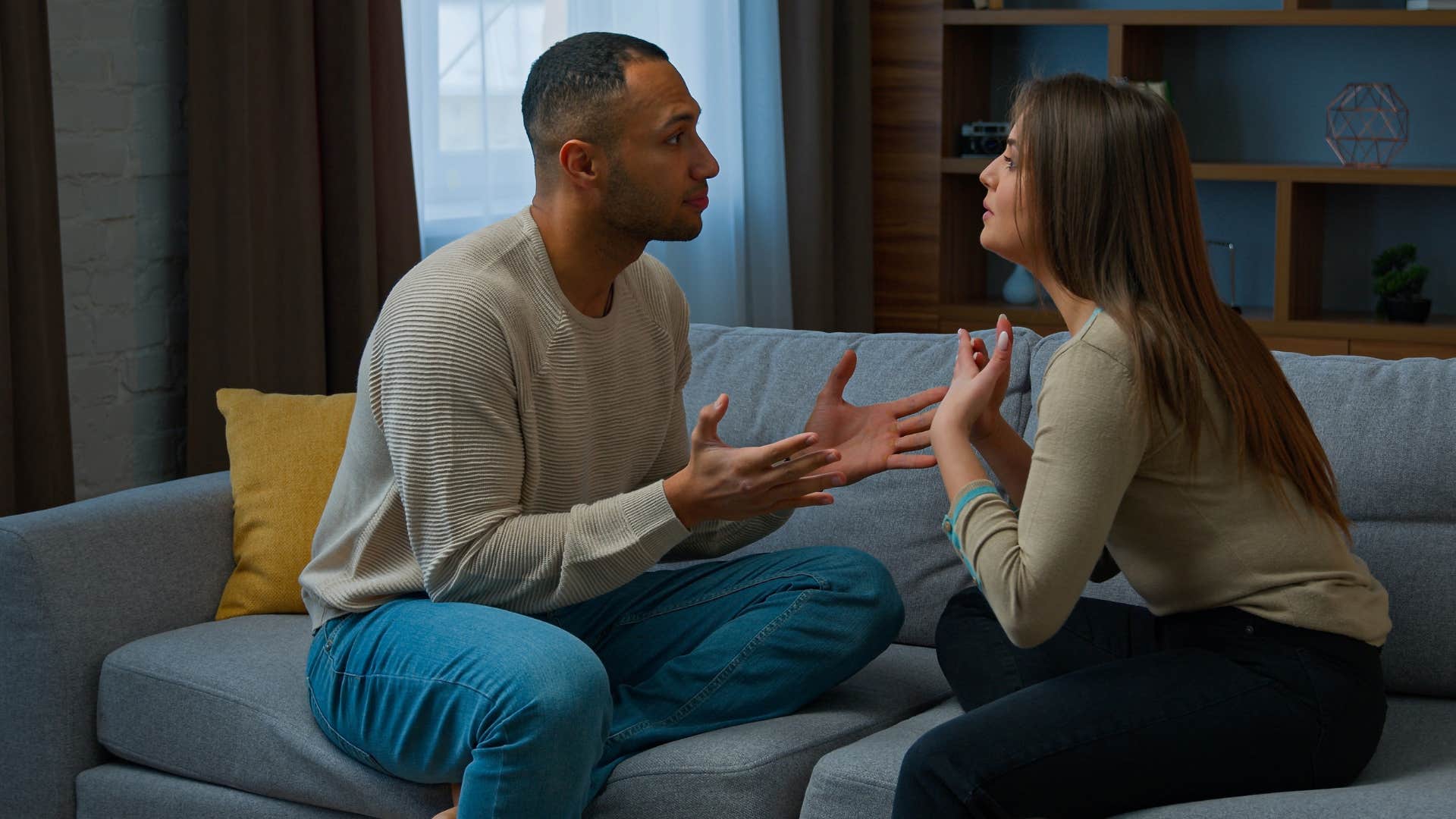 couple arguing on the couch as woman says you never