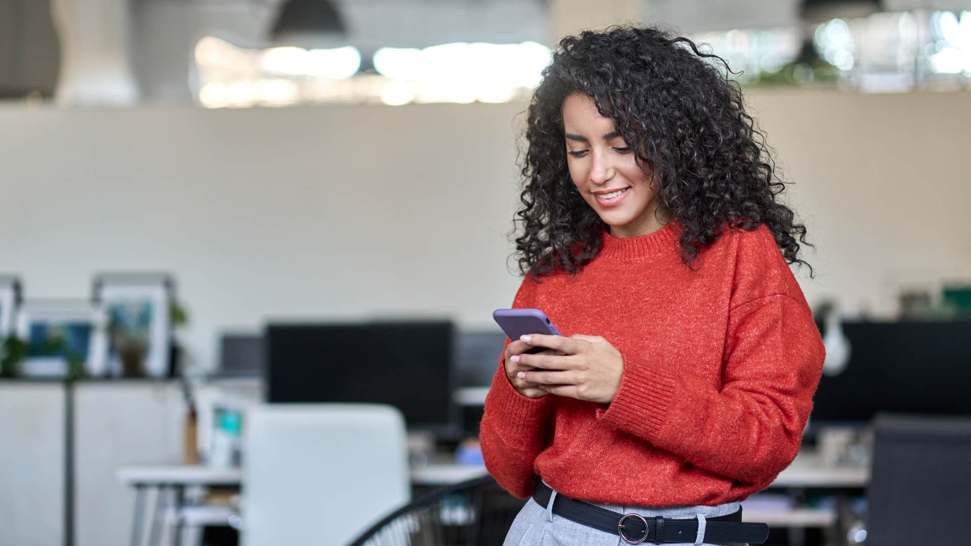 woman in red sending long thank you text messages while smiling