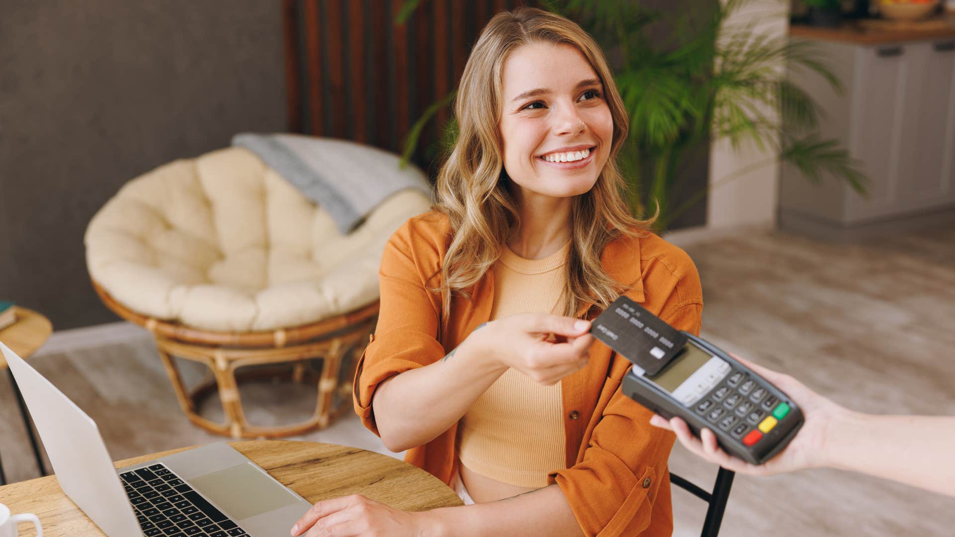 woman insisting on paying for everything as she enters in card while smiling