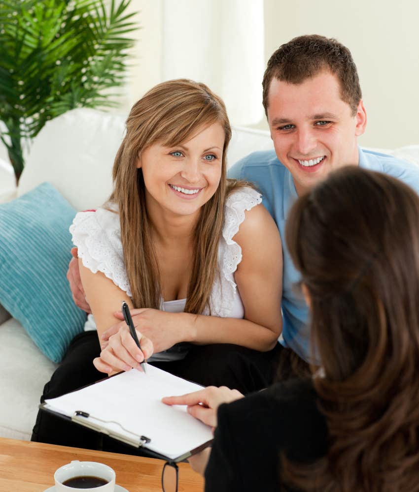 Happy couple signing a postnup