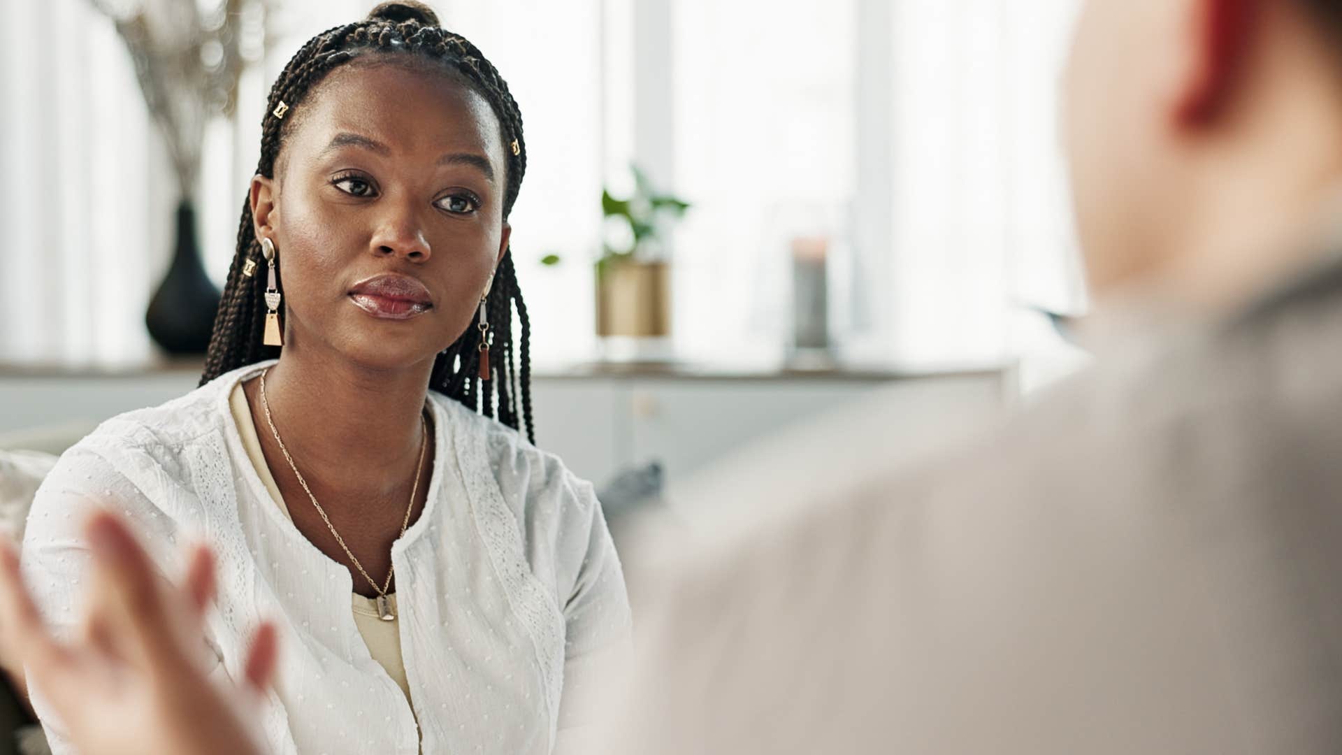 Woman who defers to others listening to a man at work.