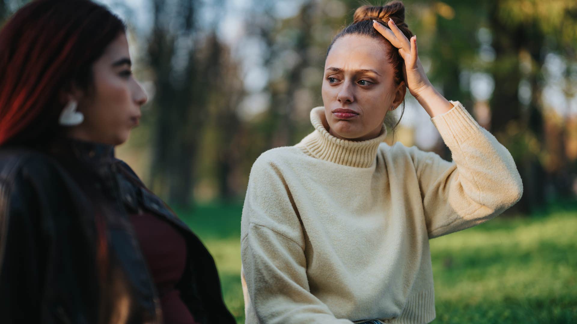 Woman who smiles less talking to a friend outside.